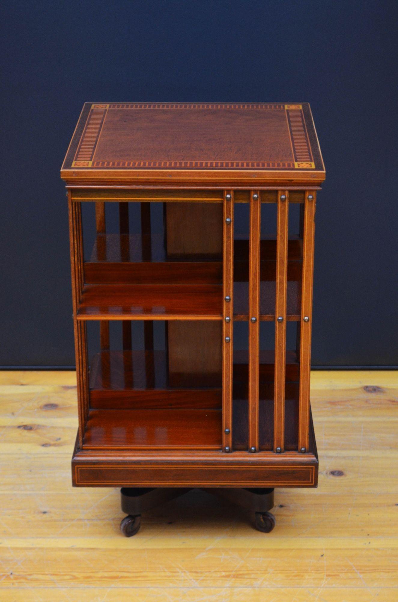 Sn5544 Fine quality English Edwardian mahogany revolving bookcase, having figured mahogany top with decorative inlays and moulded edge above four open sections with string inlaid slats, all standing on cross base reinforced with original cast iron
