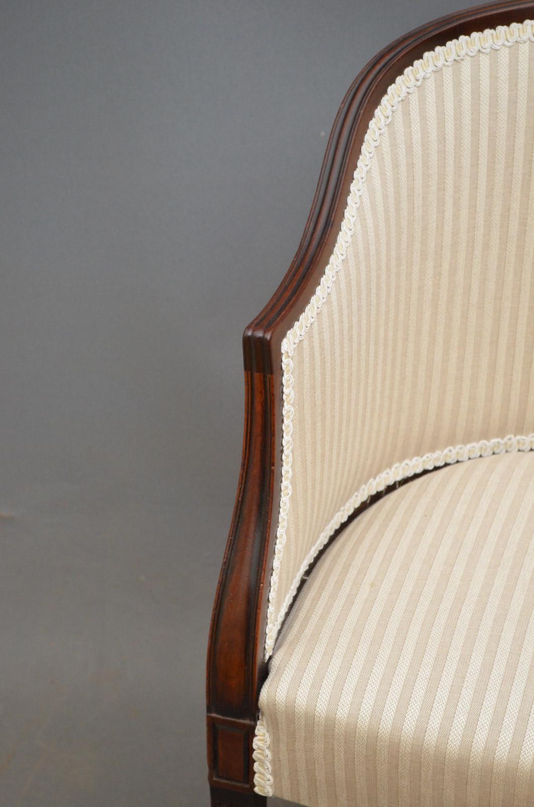 Sn3688, an elegant Edwardian tub chair in mahogany, having reeded rail terminating in shaped arms, generous seat and reeded legs terminating in pad feet. This mahogany armchair is in excellent condition throughout, ready to place at home, circa