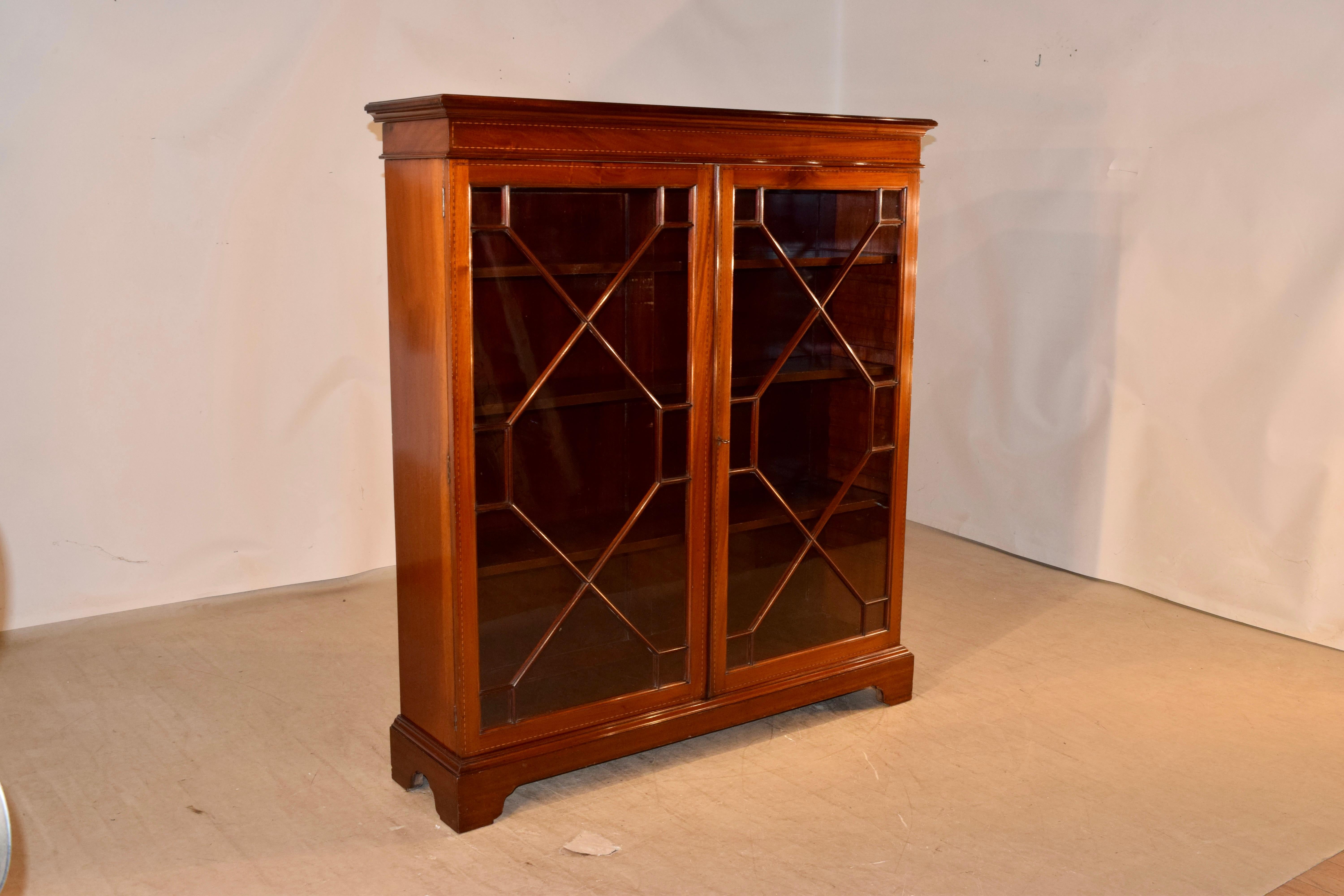 Edwardian mahogany bookcase with astragal glazed doors, circa 1920. The top has a beveled edge following down to cove molding and barber pole inlay on the front. The sides are simple mahogany and have wonderful color and patina. In the front of the