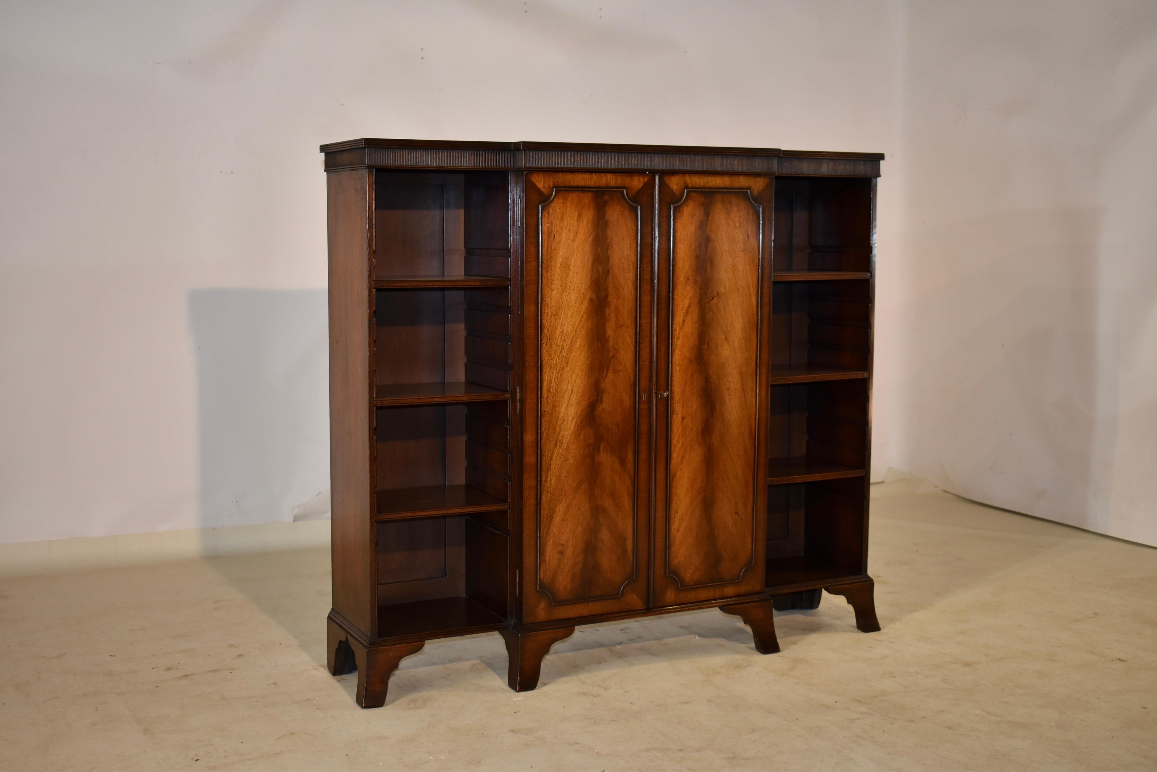 Edwardian mahogany breakfront bookcase from England which has two wonderfully grained doors made from finely figured mahogany with applied moldings. the top of the bookcase has a reeded edge and a reeded plinth beneath it for added decorative