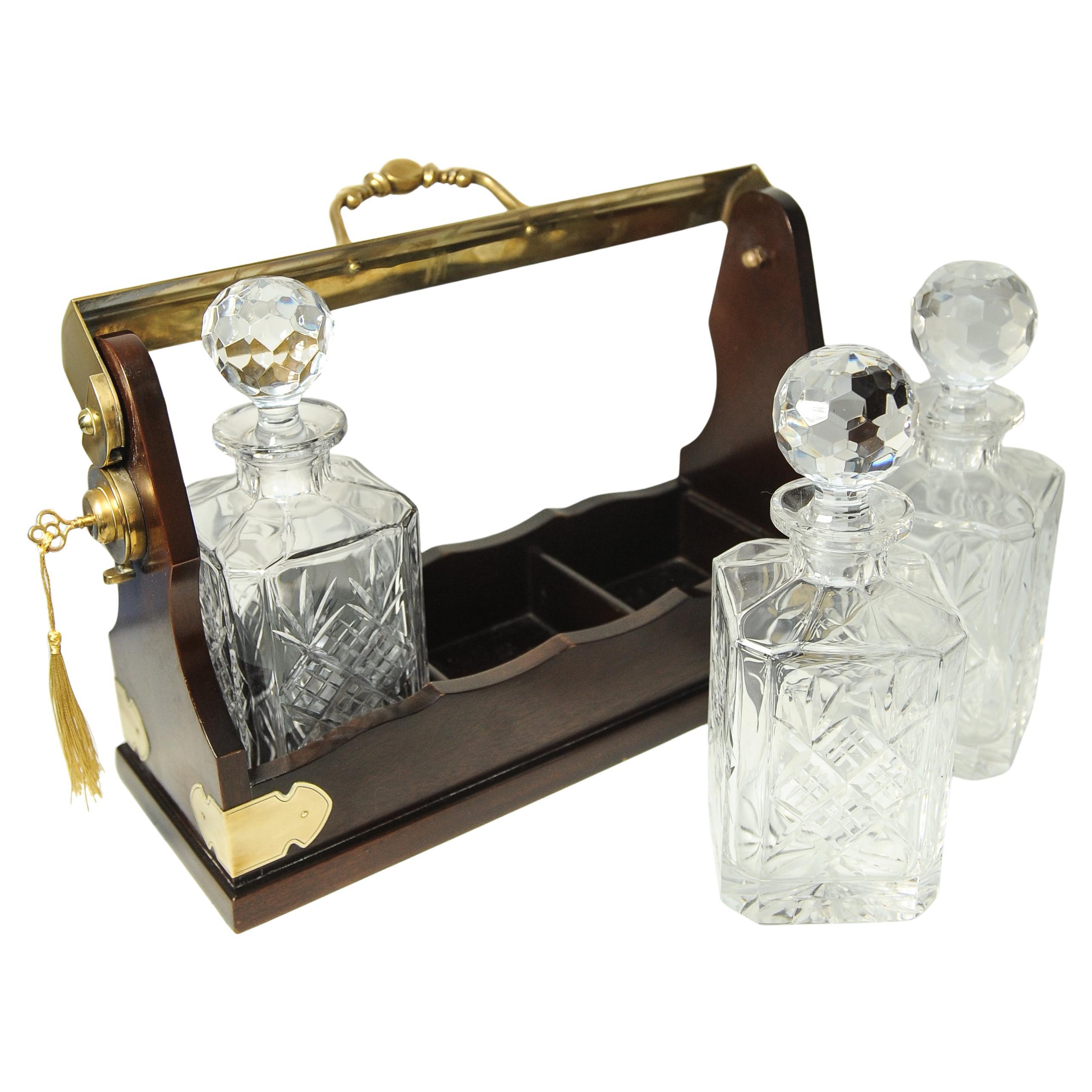 Tántalo eduardiano de caoba y latón con juego de tres decantadores cuadrados de cristal tallado con tapones de cristal tallado y elementos decorativos de latón   

Incluye una placa lisa de latón para grabar, viene con una llave de trabajo con borla