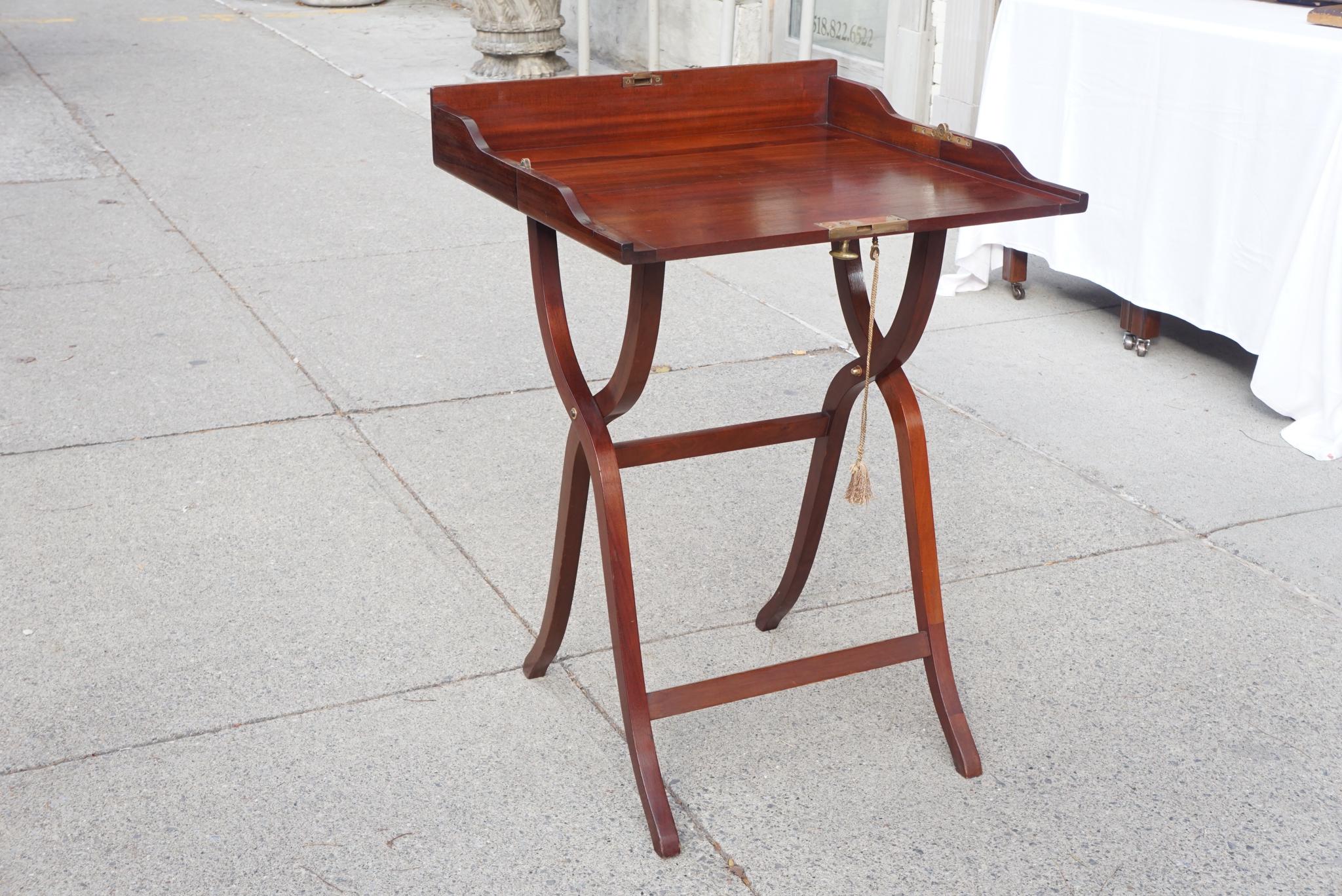 This fine period Edwardian folding camp desk is made of mahogany and some selection of nicely figured boards has occurred. The desk is of a typical form and is structurally sound being designed to house and contain materials while in transit from