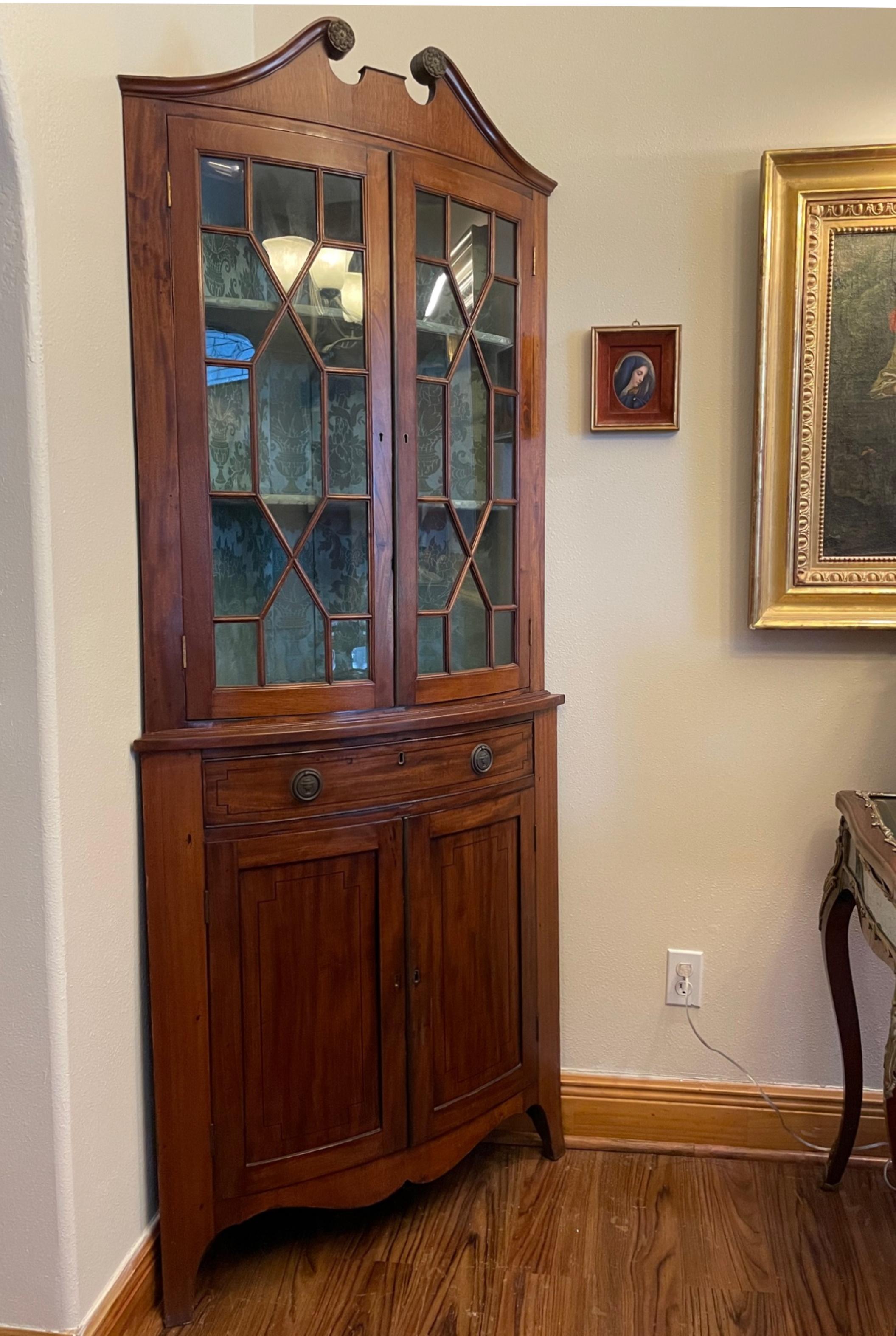 Edwardian mahogany corner cabinet.

This English mahogany cabinet is an elegant corner piece. The cupboard top is ornately glass paneled and the bottom cabinet is decoratively inlaid with satinwood. The cabinet stands on an apron with bracket feet.
