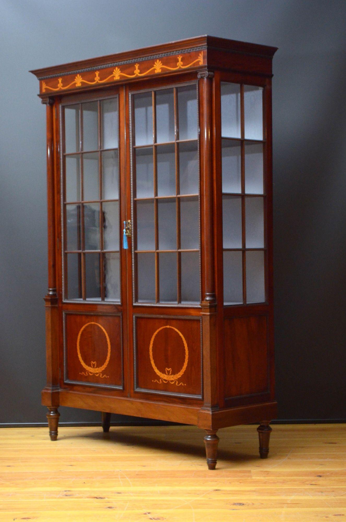 Sn5509 Elegant Edwardian china cabinet in mahogany, having cavetto cornice with egg and dart moulding above satinwood inlaid frieze and a pair of glazed doors with inlaid panels to base fitted with original working lock and a key, enclosing newly