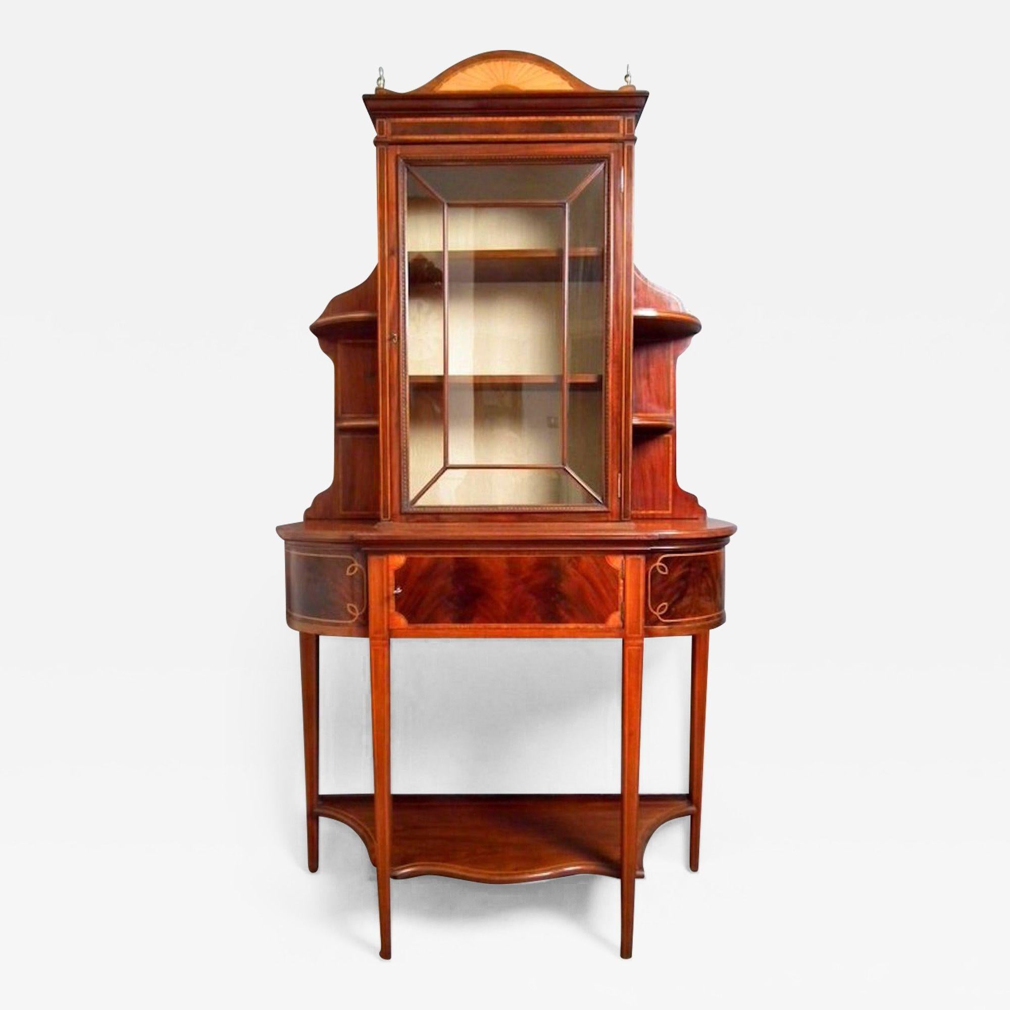 SN2132 Truly excellent, Edwardian, mahogany display cabinet, having arched pediment inlaid with satinwood fan flanked by brass finials above flamed mahogany, inlaid frieze, astragal glazed door flanked by crossbanded, corner shelves. Lower part,