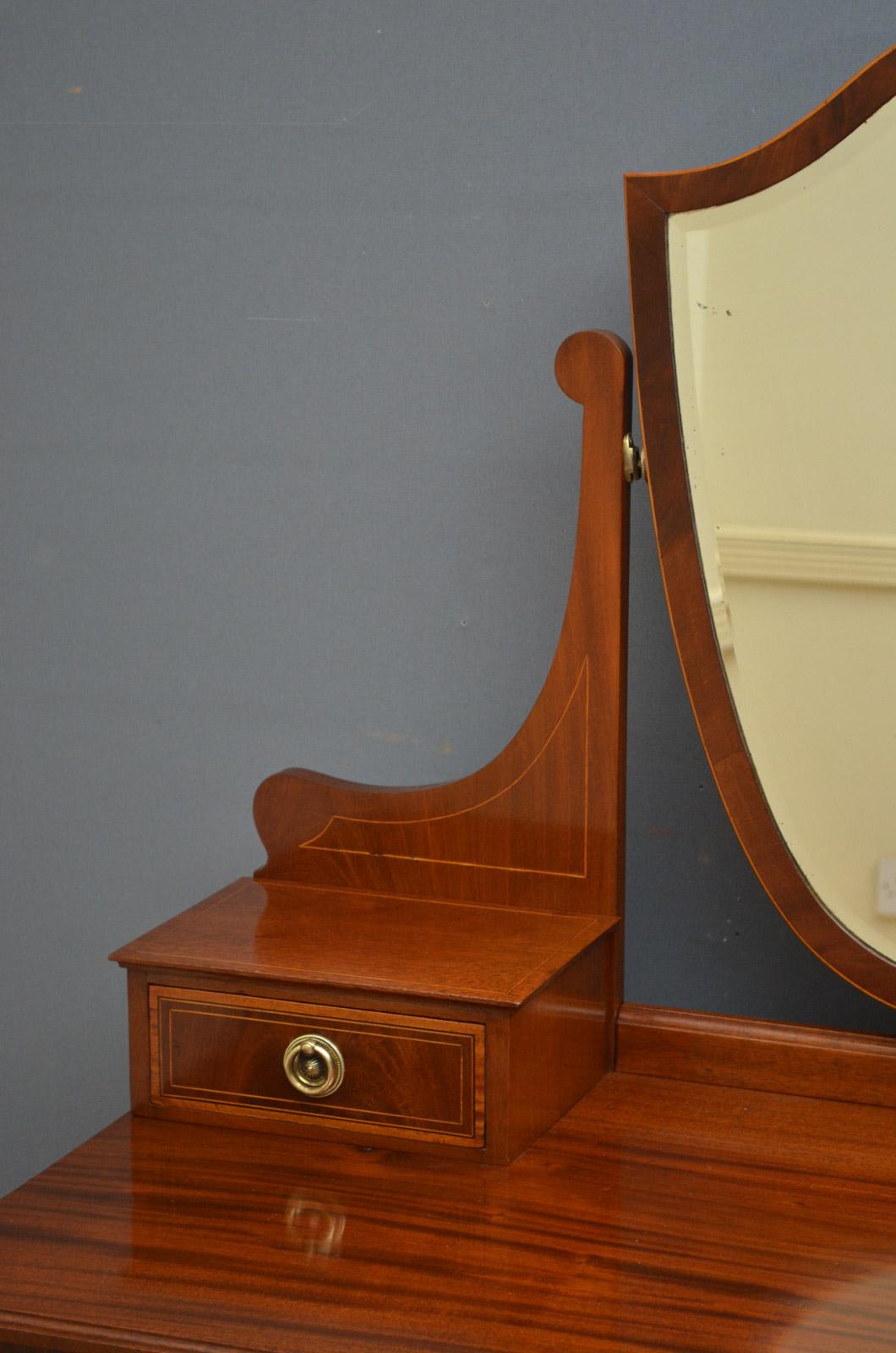 Sn4530 Edwardian dressing table in mahogany, having shield shaped mirror in shaped supports terminating in small drawers, figured mahogany moulded top and satinwood inlaid drawers all fitted with original brass handles and standing on tapering legs