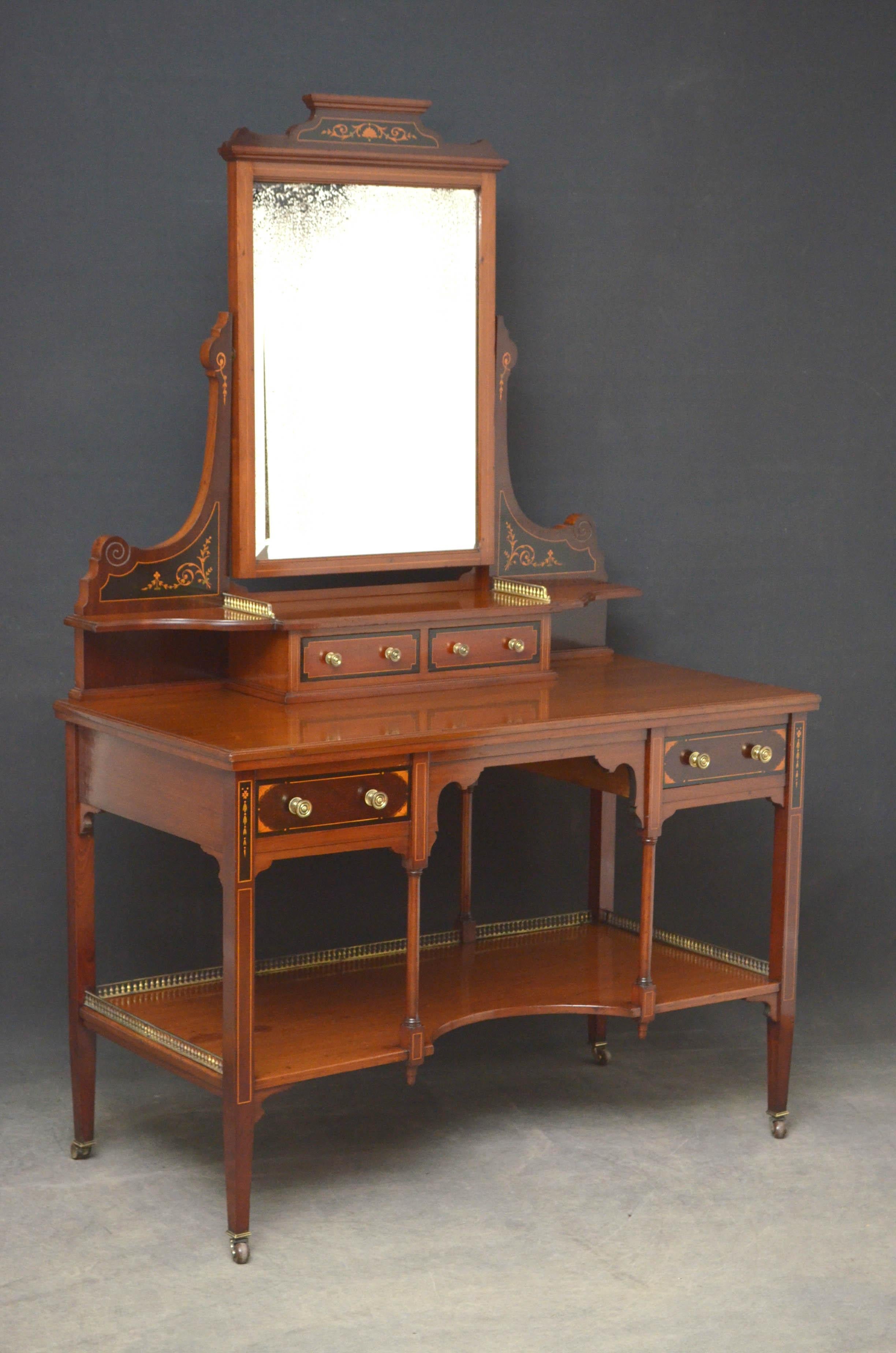 R00 stylish Edwardian dressing table in mahogany, having original bevelled edge mirror with some foxing (can be replaced on request) on carved and inlaid uprights terminating in shaped tier with brass gallery and inlaid jewelry drawers all above