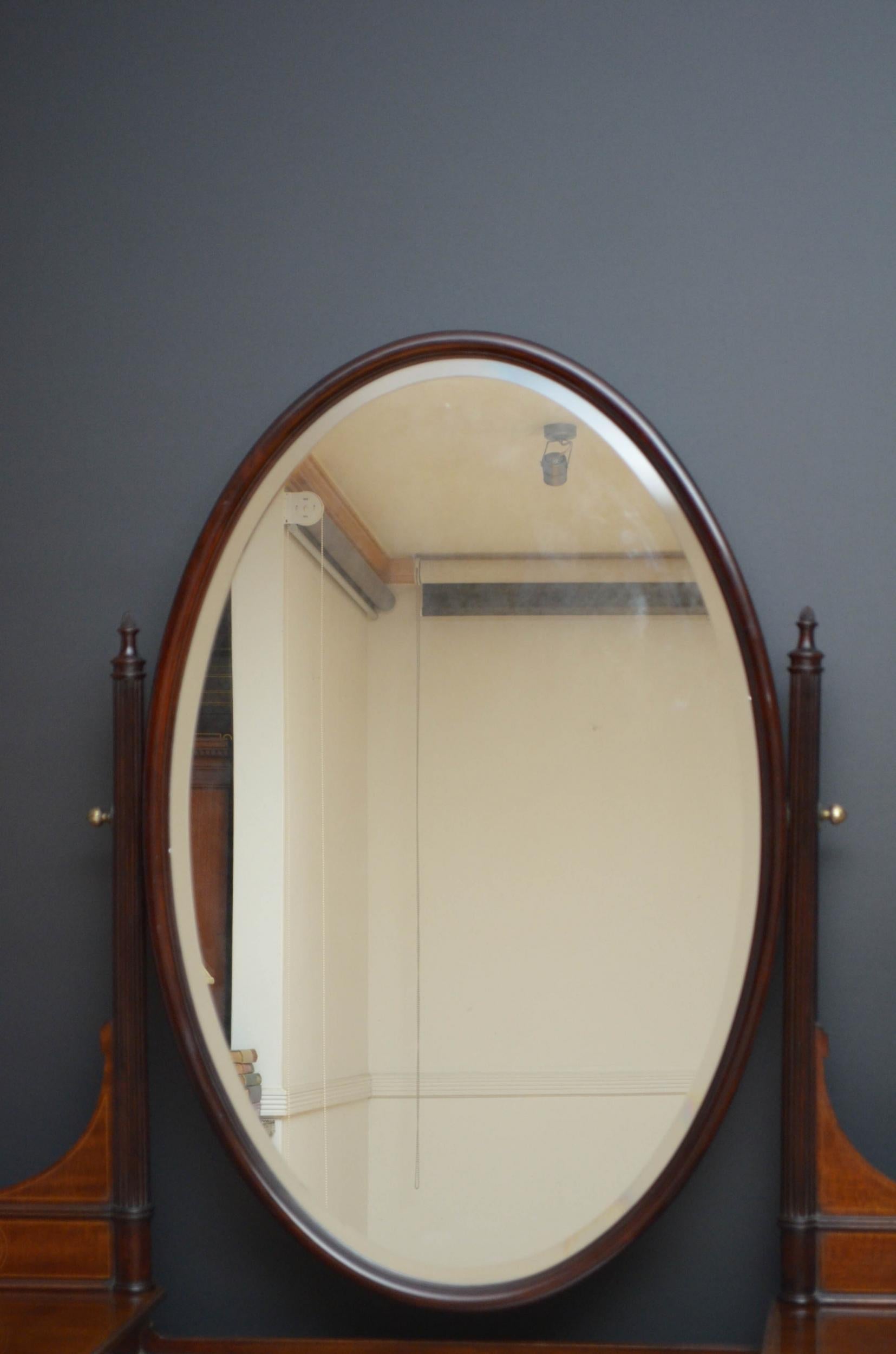 Sn5073 Superb quality Edwardian, mahogany dressing table, having original oval bevelled mirror held by reeded uprights fitted with inlaid supports above a drop centre top with jewellery compartment and concave single drawer flanked by twin drawers,