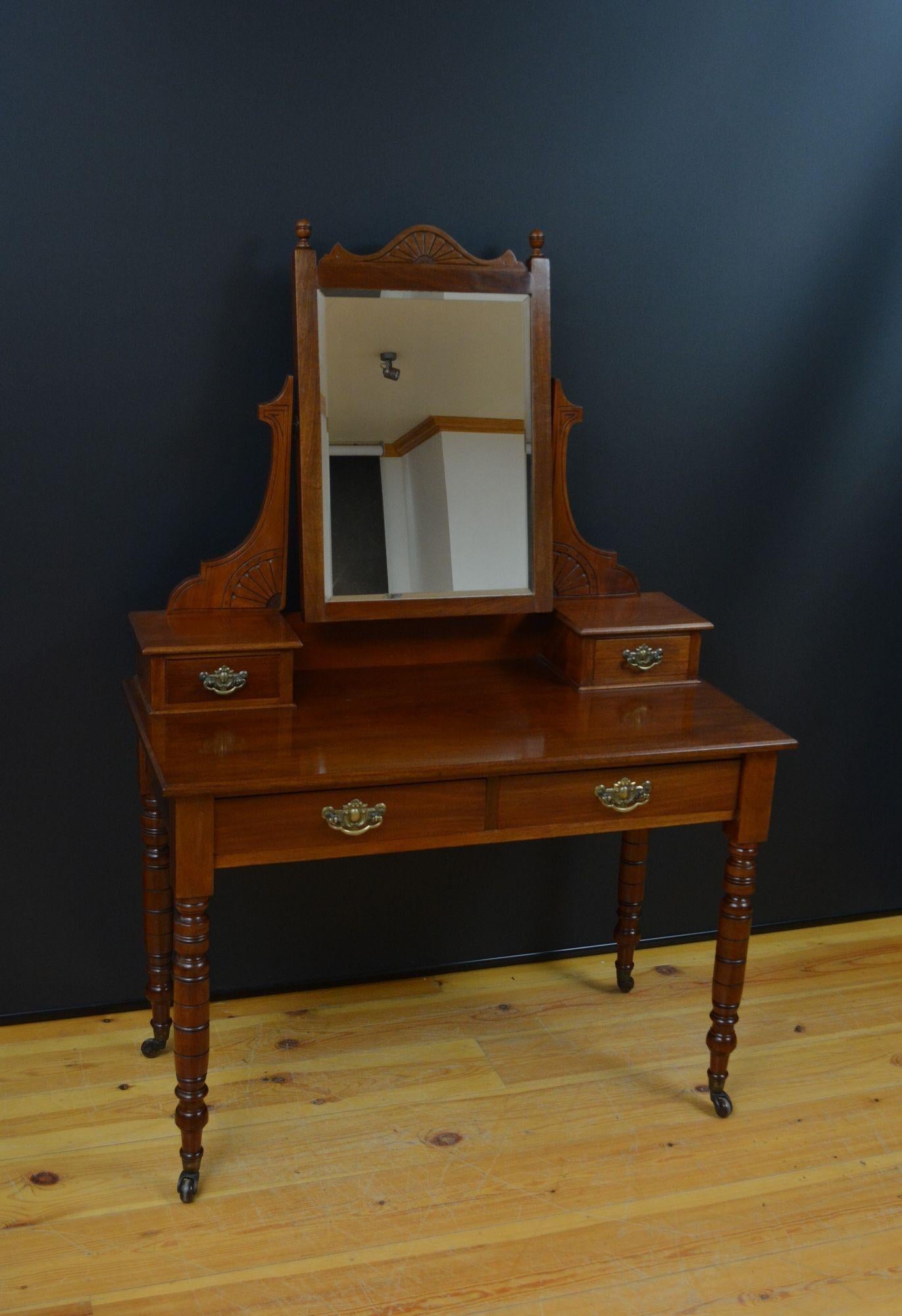 J043 Edwardian mahogany dressing table with bevelled edge mirror and carved supports, terminating in two small drawers above a moulded top and 2 frieze drawers, fitted with original brass handles, all standing on turned legs and original brass