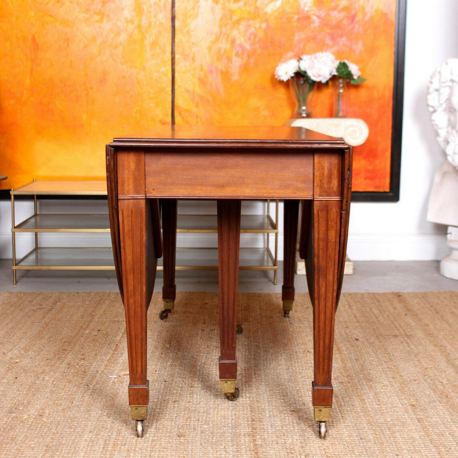 An impressive Edwardian gateleg dining table.
Constructed from thick cuts of solid oak boasting a well figured wild grain.
The top with twin chamfered edge having rounded ends supported on square fluted tapering legs with brass cappings and