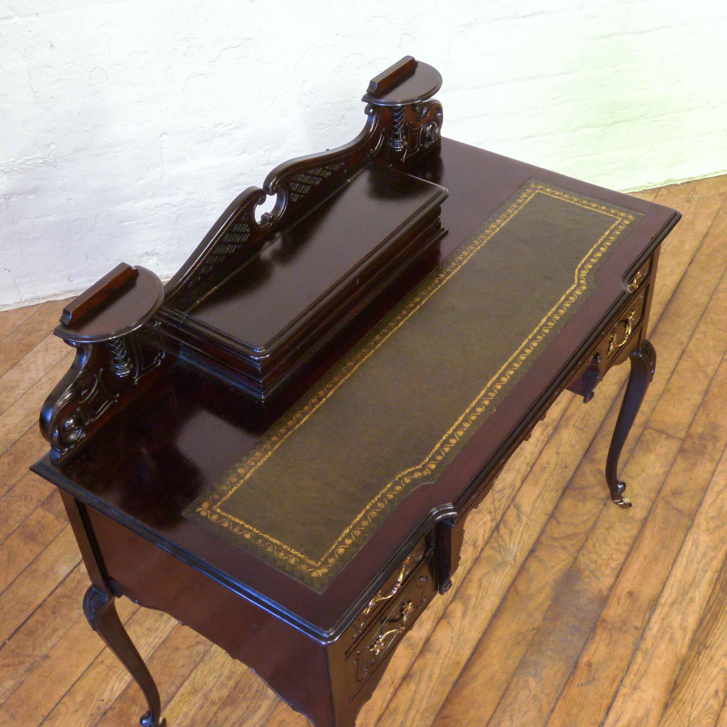 A very attractive mahogany ladies writing desk with a strong French Rococo influence. It has two side drawers and a central compartment fitted for letters and an inkwell. The top has a new tooled leather writing surface and the whole is in very good