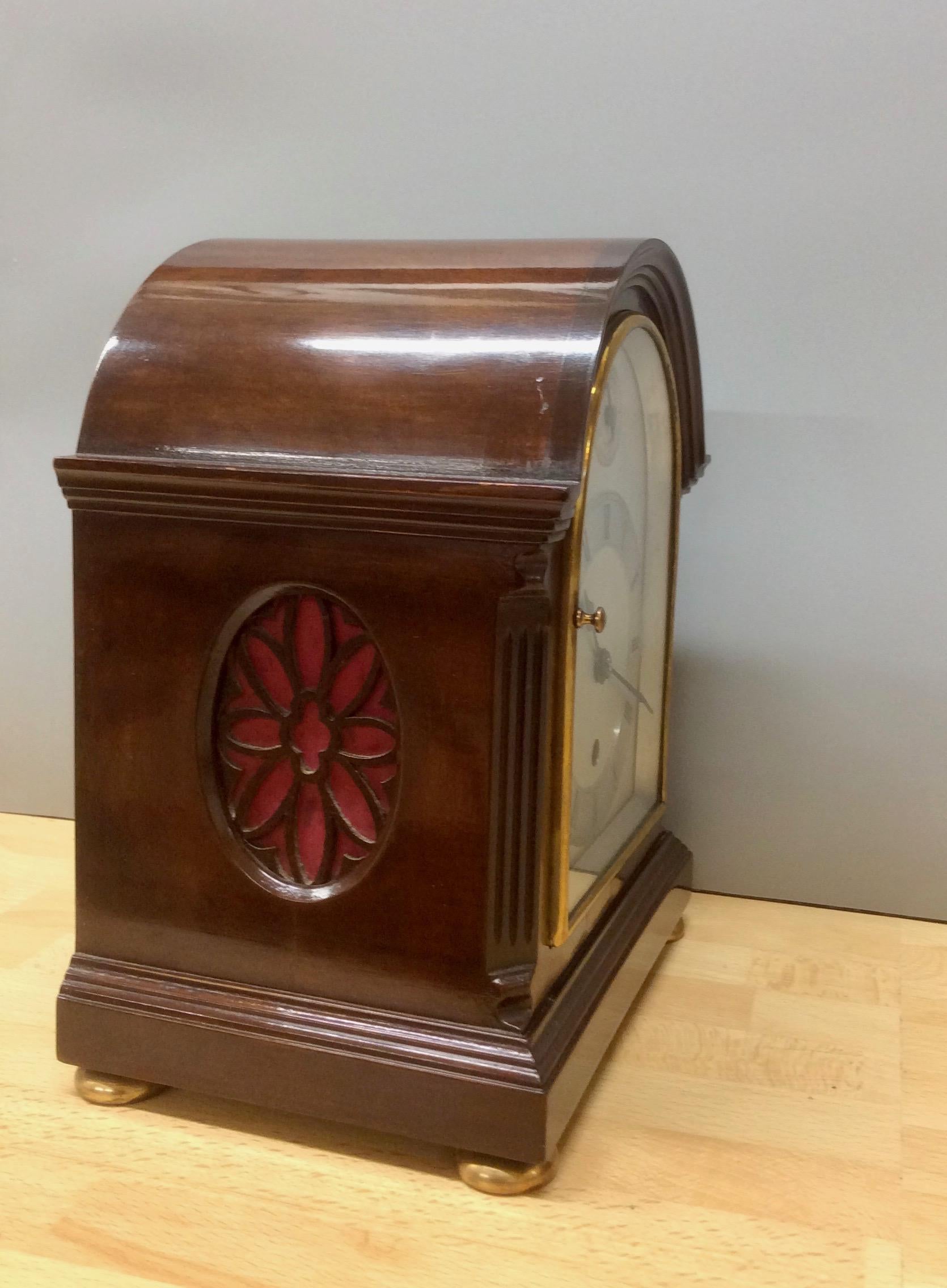 Edwardian miniature mantel clock standing on brass bun feet and a raised moulded plinth with canted reeded corners in a break arch case

Gilded, hinged bezel supporting a silvered dial, chapter ring with Roman numerals, subsidiary dial for slow /