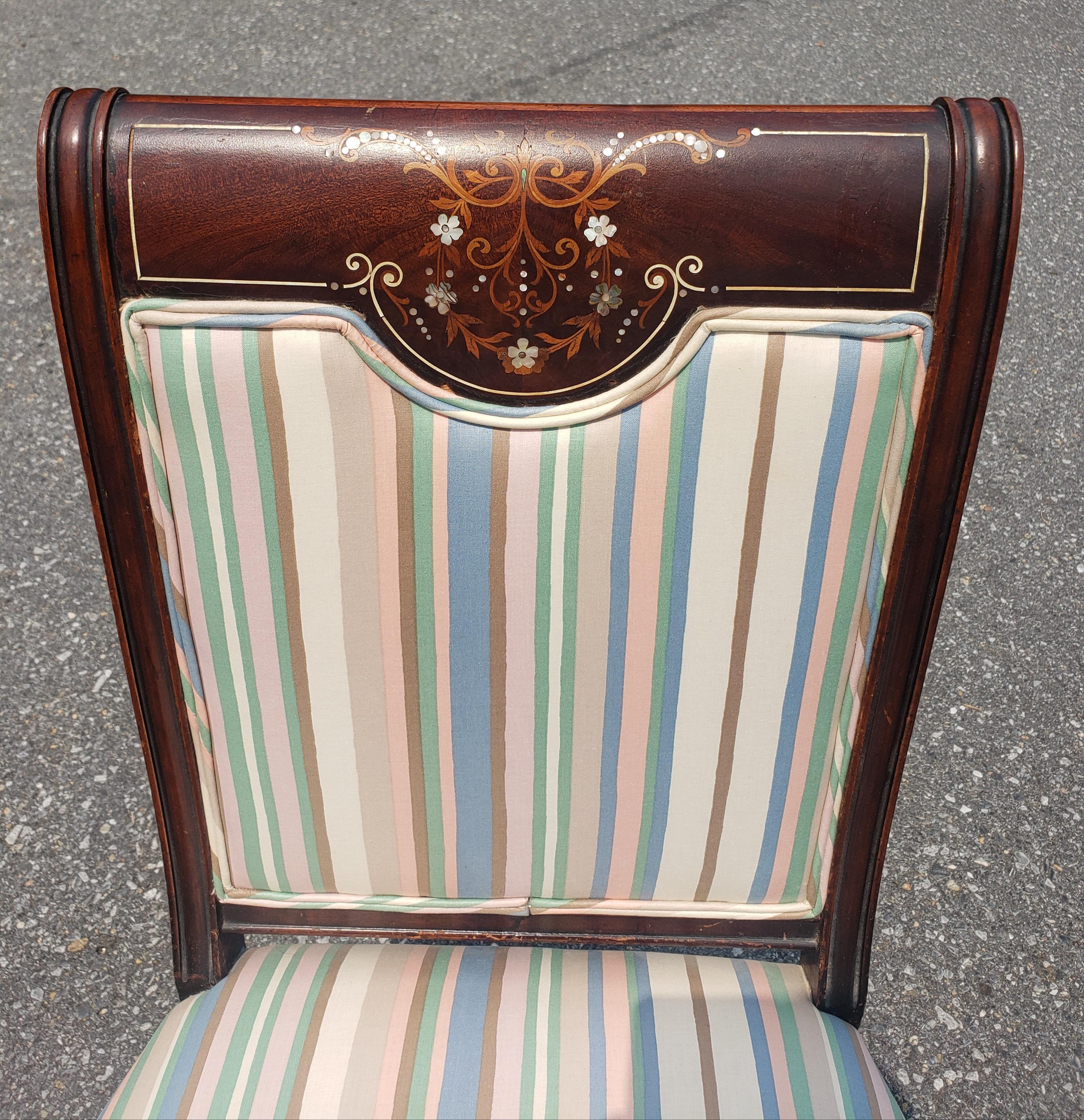 An Edwardian Mahogany Mother-Of-Pearl And Satinwood Inlaid Side Chair in good vintage condition. Wooden front wheels. Mother of peal inlay. Satinwood inlay. Newer and Clean Upholstery Measures 19