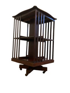 Edwardian Mahogany revolving Bookcase on casters and slatted supports.