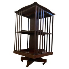 Edwardian Mahogany revolving Bookcase on casters and slatted supports.