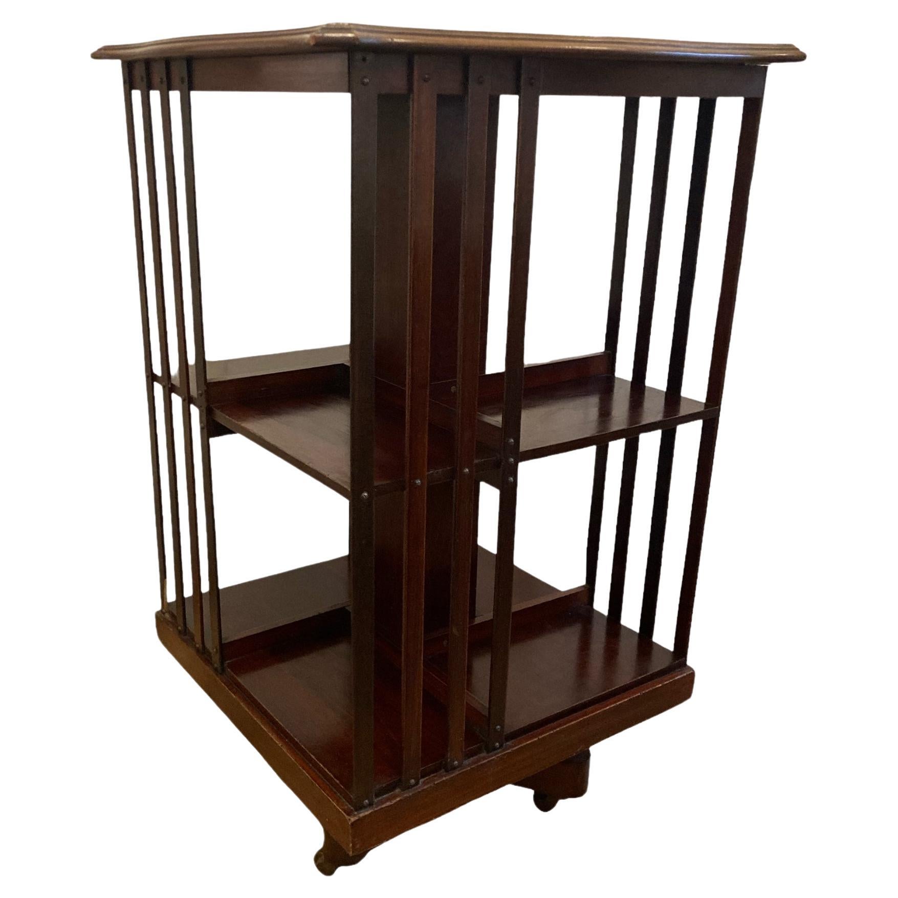 Edwardian Mahogany revolving Bookcase on casters and slatted supports.