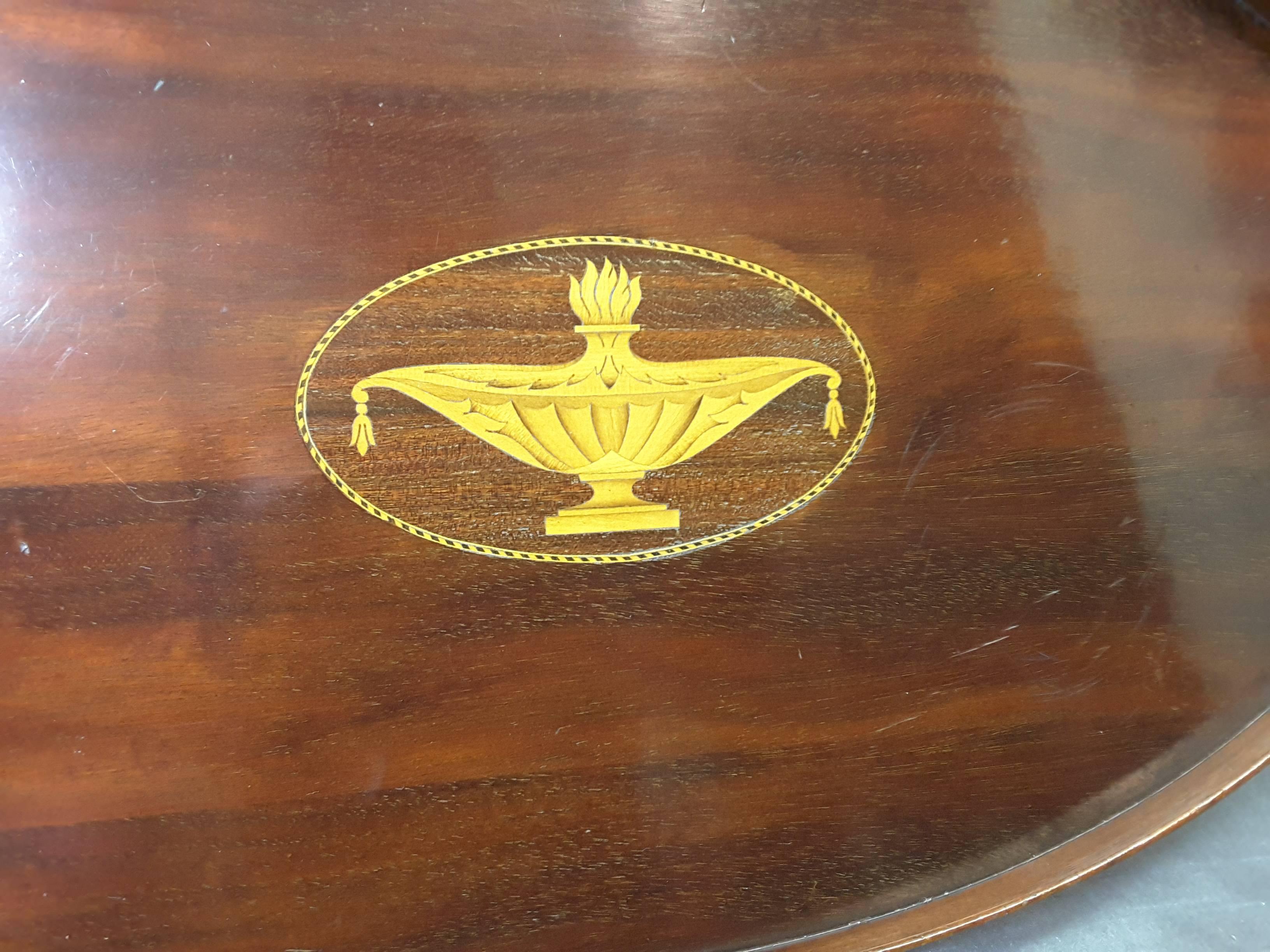 Edwardian mahogany serving tray by Manning Bowman & Co. Made in Middletown, Connecticut. An Oval tray with solid brass handles, with a Grecian urn inlaid in the centre, raised gallery edge, Original label and Impressed stamp on the bottom. There are