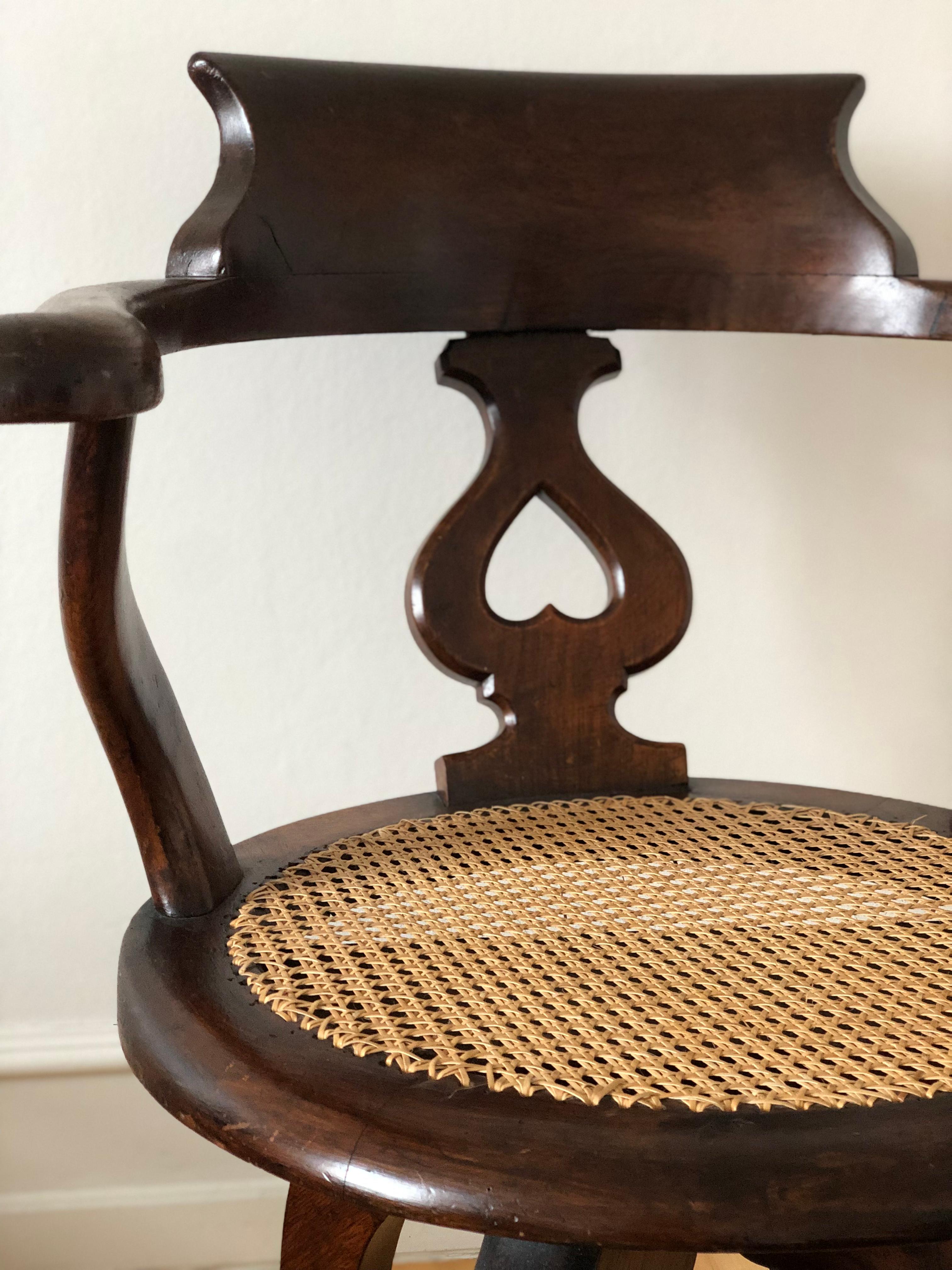 An elegant English office swivel chair from the late 19th century, crafted from solid mahogany and finished with cane. Sturdy, comfortable, and timeless, it stands on antique castors for easy mobility. In good condition, this chair combines