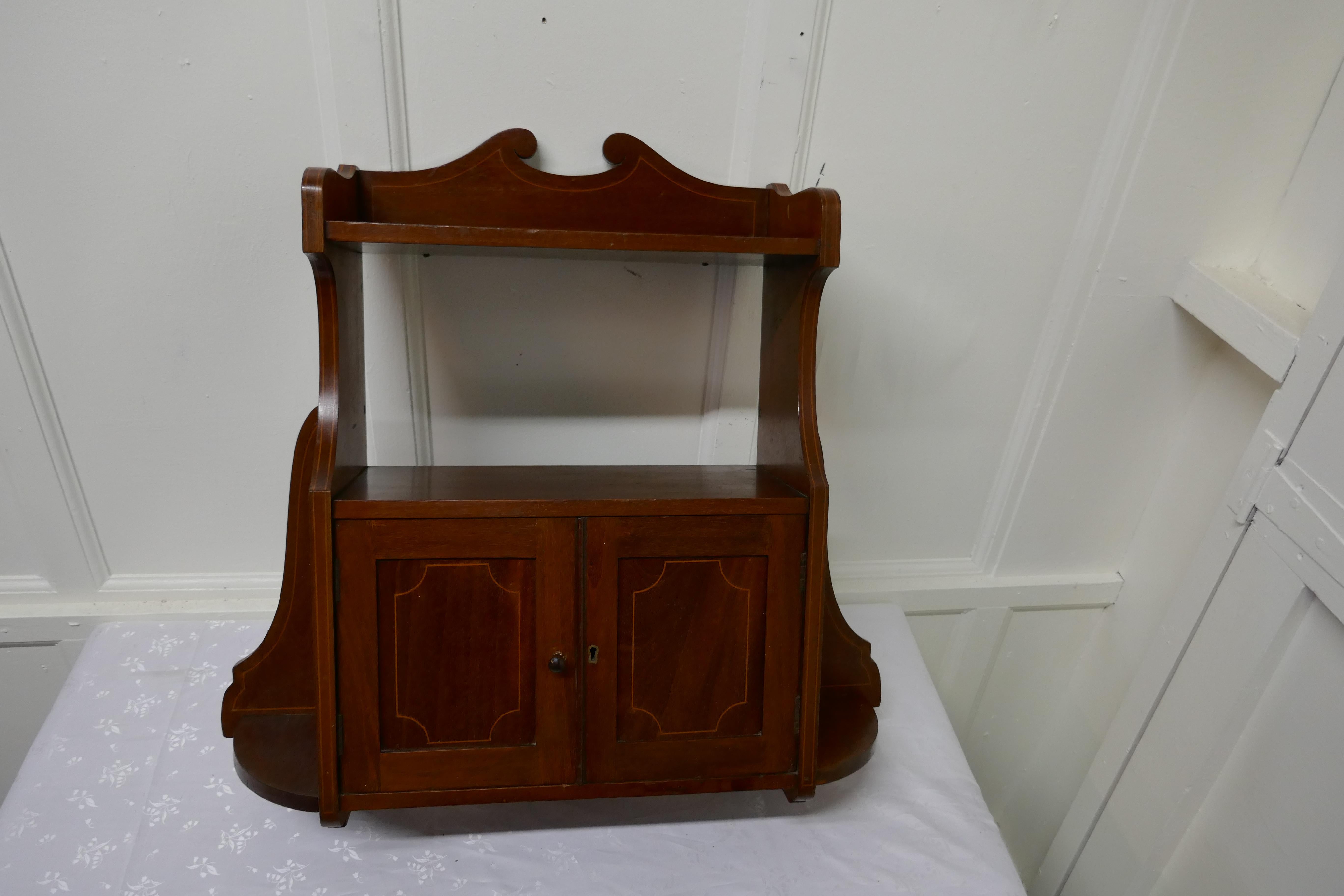 Edwardian mahogany wall cabinet

A great little piece, made in mahogany with a delicate boxwood string inlay on the front, the cabinet has a top galleried shelf and another over the double door cabinet
The interior of the cabinet has some water