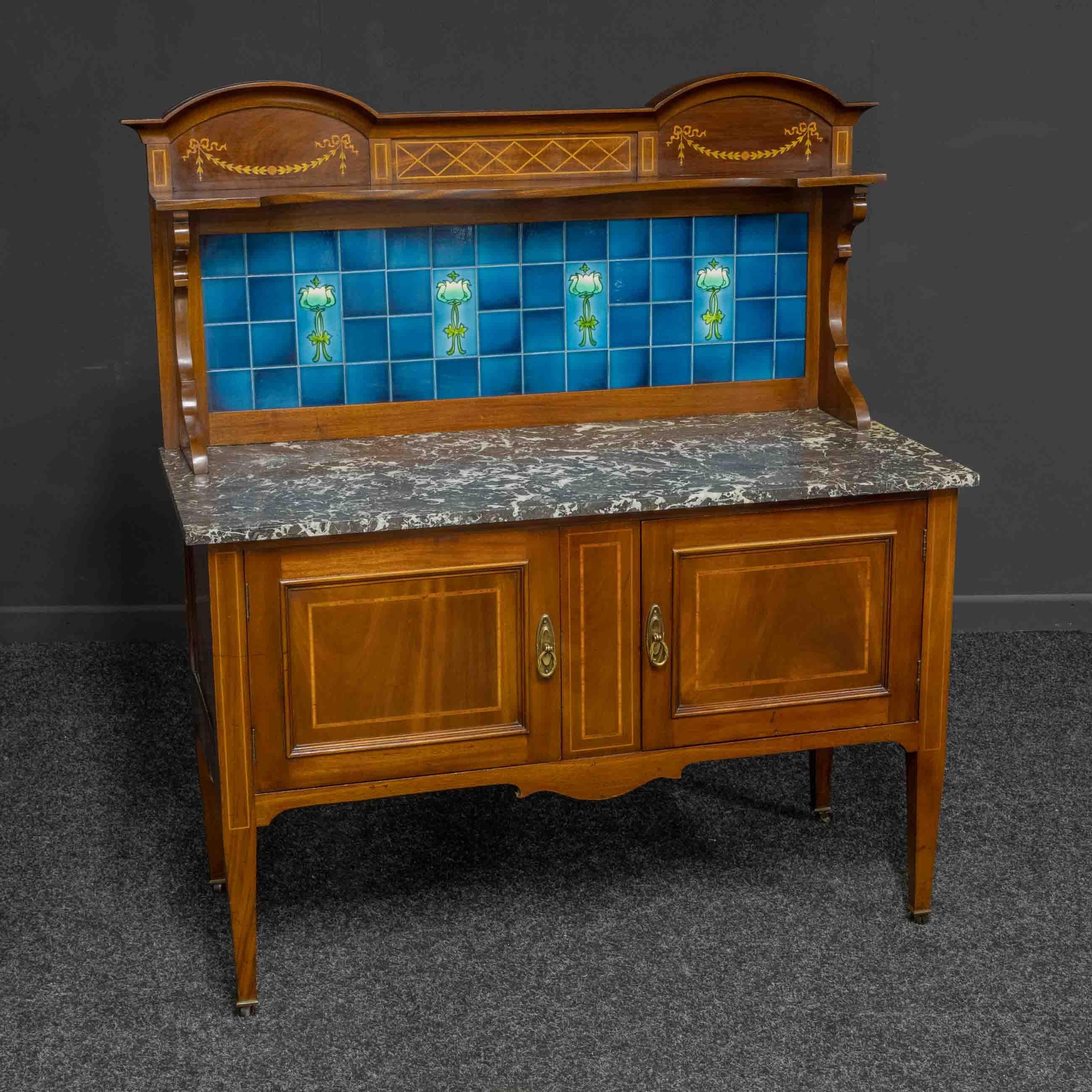 A stunning high quality Edwardian washstand of large proportions. The base is sat on tapering legs with their original brass castors. Supporting two cupboard doors inlaid with both crossbanding and string inlays. Above is a heavy grey and white
