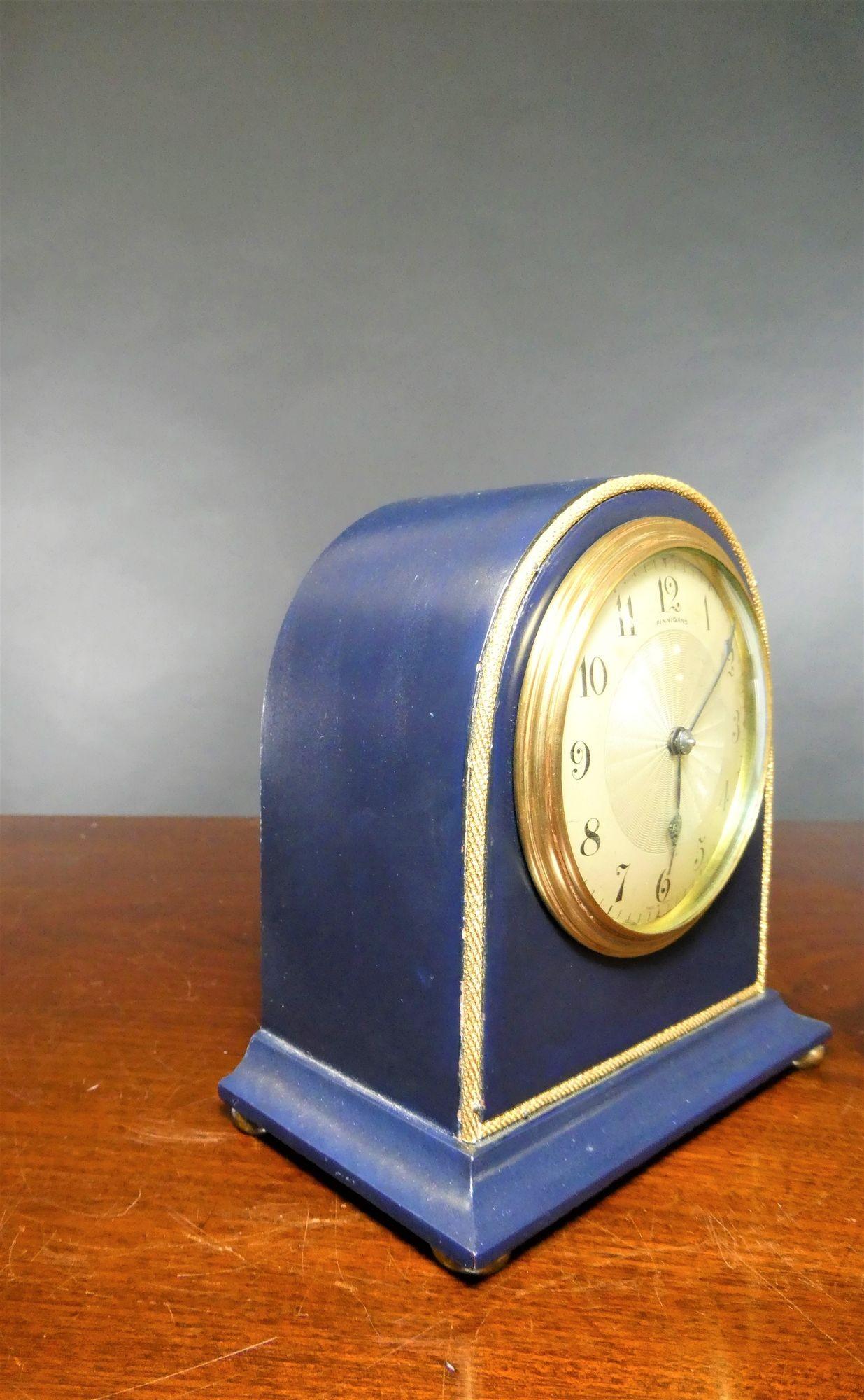 Arch top mantel clock standing on four brass bun feet with gilded decoration and brass bezel. Silvered dial with engine turned centre, Arabic numerals, original ‘blued’ steel hands signed ‘Finnigans’.
 
Eight day French movement with platform