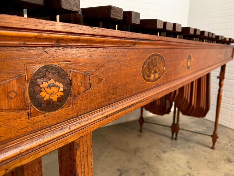 Antique Edwardian Marimba Xylophone with a combination of hardwoods and iron. 
There are two separate tables that bolt together. Each marimba breaks down for transport into three pieces with foldable legs. Only the front instrument has the