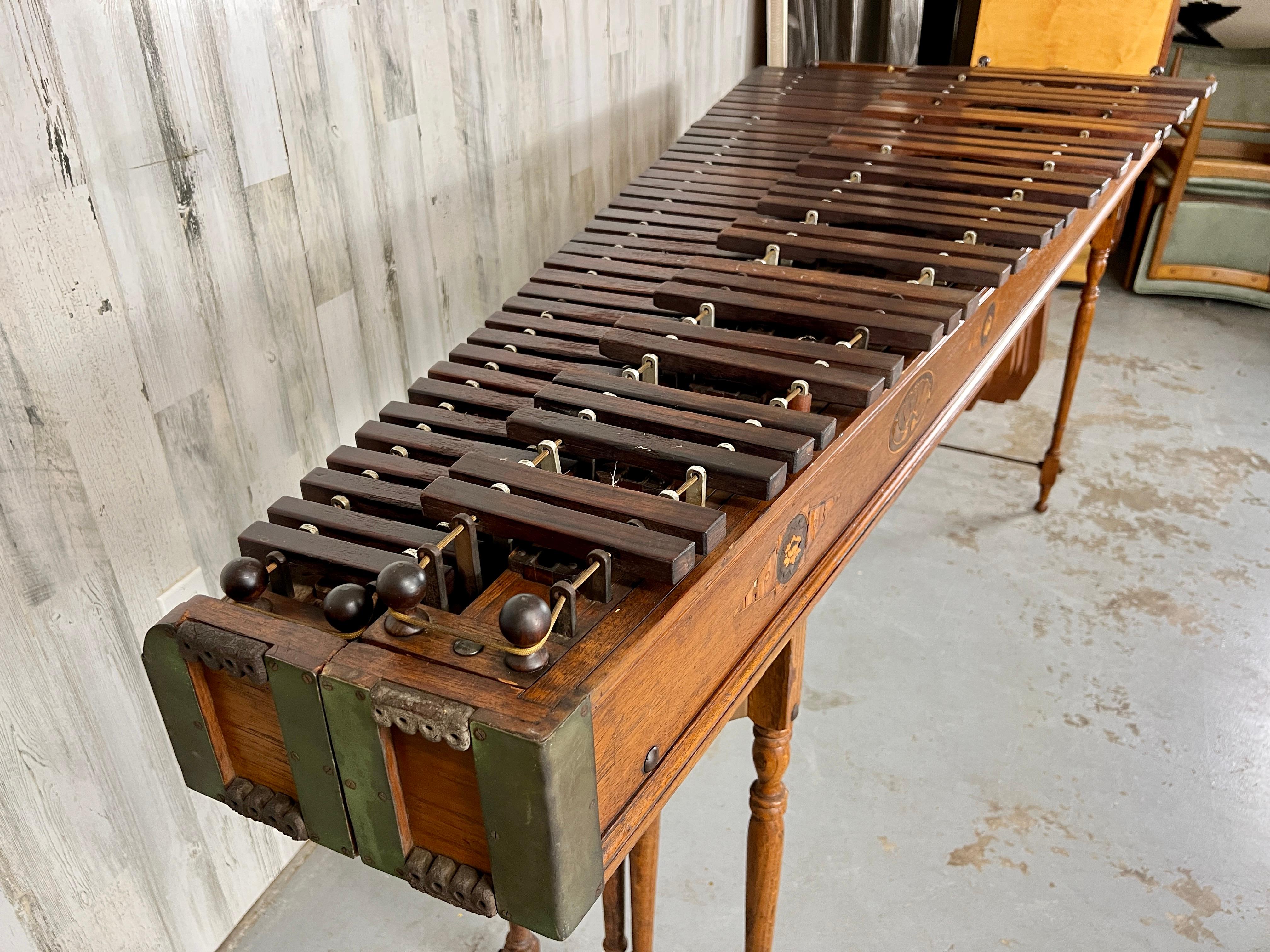 Antique Edwardian Marimba Xylophone with a combination of hardwoods and iron. 
There are two separate tables that bolt together. Each marimba breaks down for transport into three pieces with foldable legs. Only the front instrument has the
