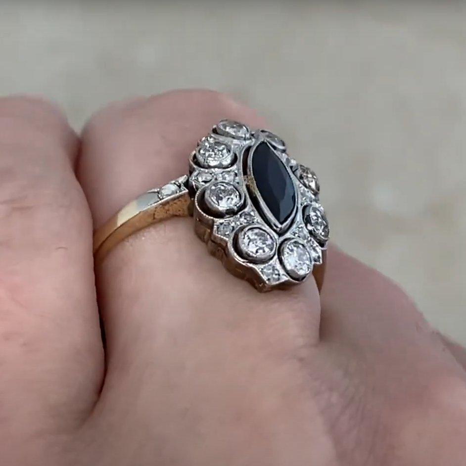 Este exquisito anillo de la época eduardiana muestra la elegancia atemporal de la artesanía de principios del siglo XX. En su centro hay un cautivador zafiro talla marquesa, de aproximadamente 0,70 quilates, sujeto en un engaste clásico de bisel. El