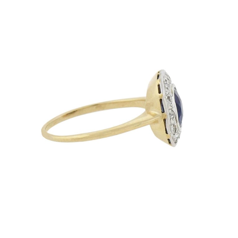 An outstanding sapphire and diamond ring from the Edwardian (ca1910) era! Crafted in 14kt yellow gold and platinum, this mixed metals piece adorns a stunning sapphire at the center of a sparkling diamond border. The oval-shaped sapphire weighs