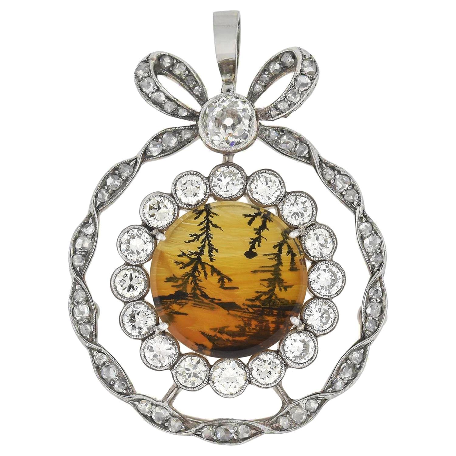 An absolutely fabulous and unique diamond and agate pendant from the Edwardian (ca1910s) period! This very unusual piece portrays 2 sparkling diamond rings and a lovely bow resting on top. The pendant, which is fairly large in size, is crafted in