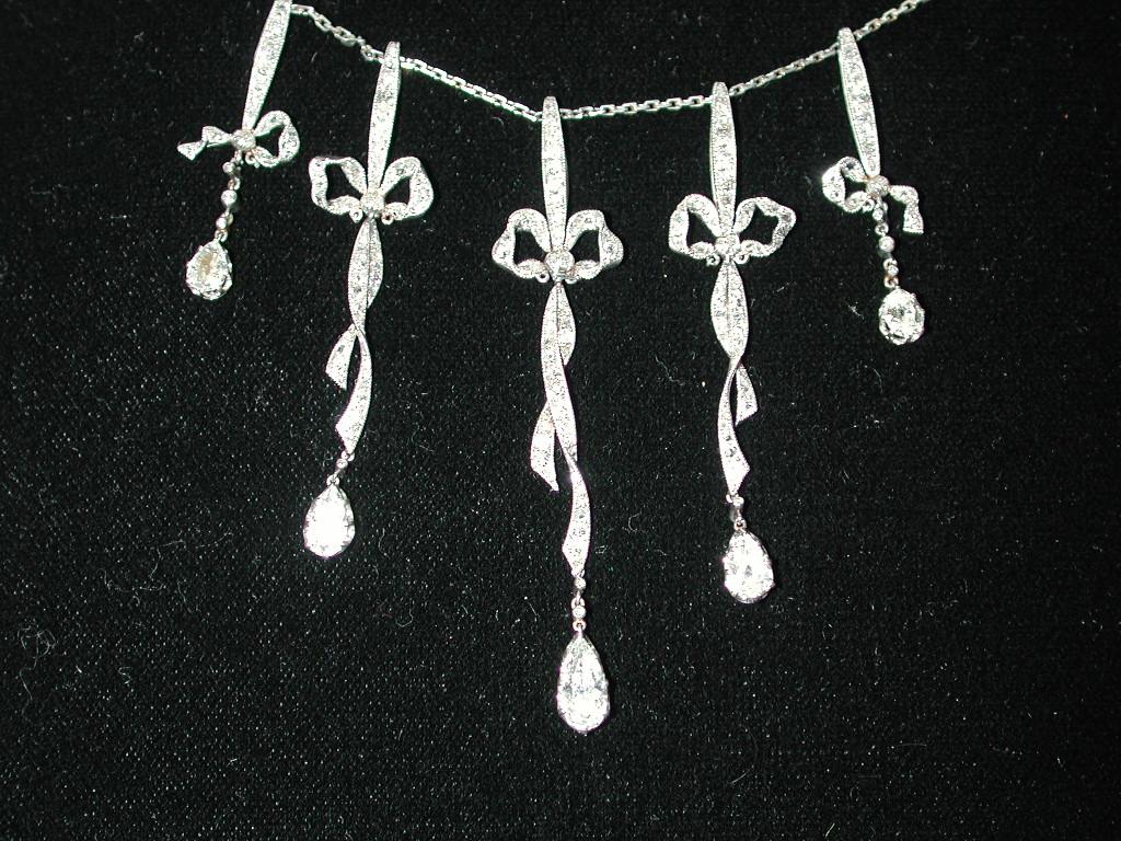 Edwardian Multi Diamond Necklace with Integral 18ct Gold Chain, Dated Circa 1910
This necklace is very Belle Epoque, probably made in Paris.
It has 5 pear shaped diamonds hanging below 5 exquisite diamond studed bows.
The bows are a mixture of old