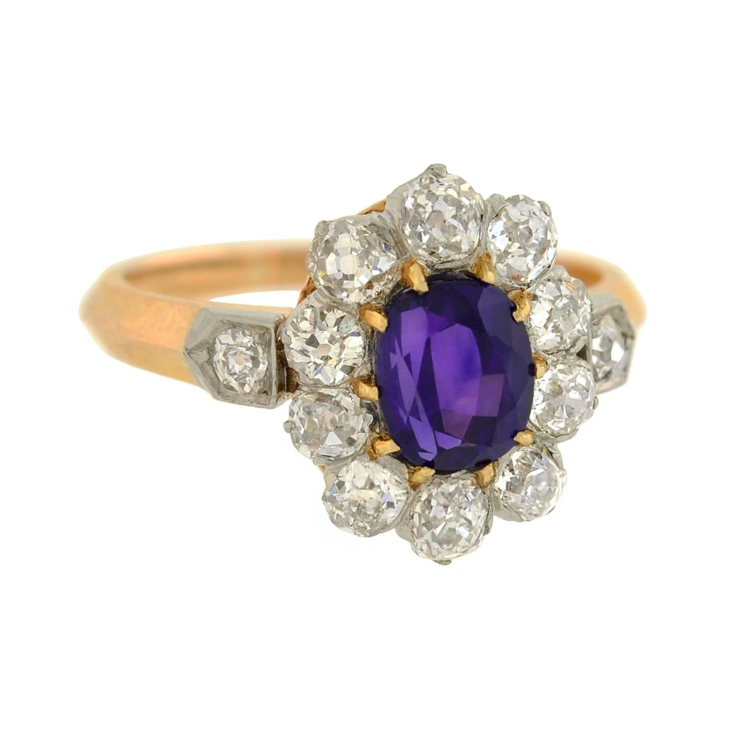 A rare and exquisite gemstone ring from the Edwardian (ca1910) era! Crafted in 18kt gold and platinum, this handmade piece features a faceted sapphire at the center of an old Mine Cut diamond border. The oval cut sapphire, which is prong set in