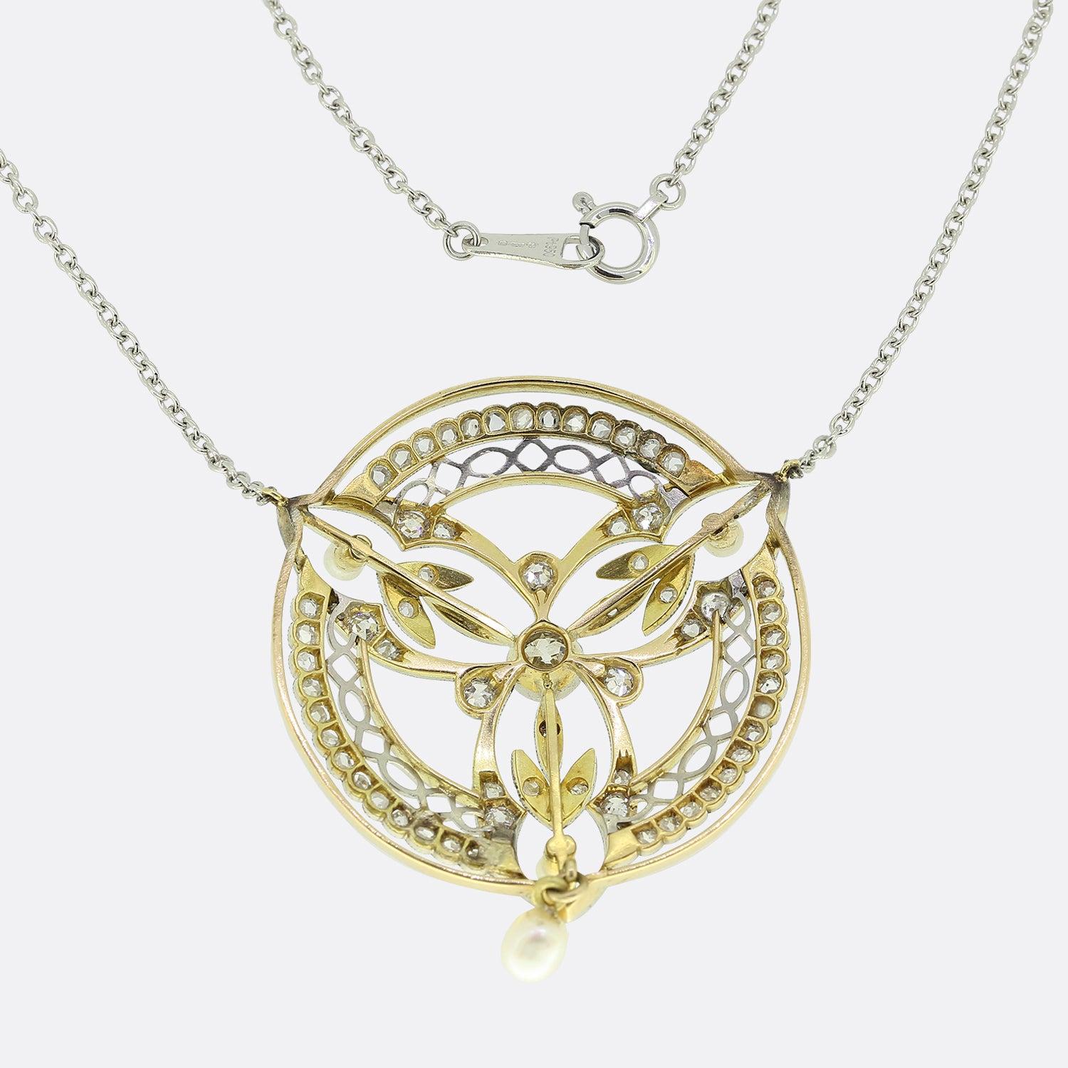 Si tratta di una collana edoardiana con ciondolo in oro giallo 18ct e platino. Il ciondolo è realizzato in un meraviglioso stile floreale ed è incastonato di diamanti con un grande diamante vecchio taglio al centro e tre perle naturali. La collana