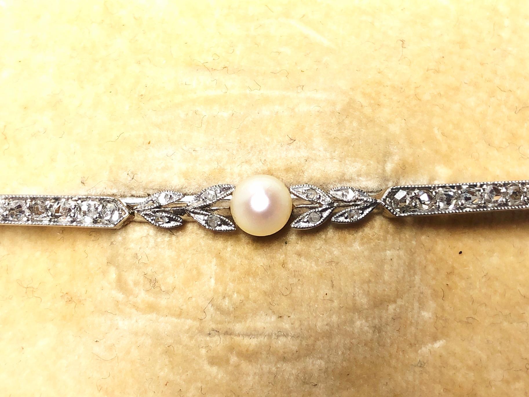 A natural pearl and diamond bar brooch, centrally set with a 5.2mm natural pearl, with graduating rose cut diamonds to each side, set in an elongated bar, with an estimated total diamond weight 0.60ct, mounted in platinum. Circa 1910.

The brooch