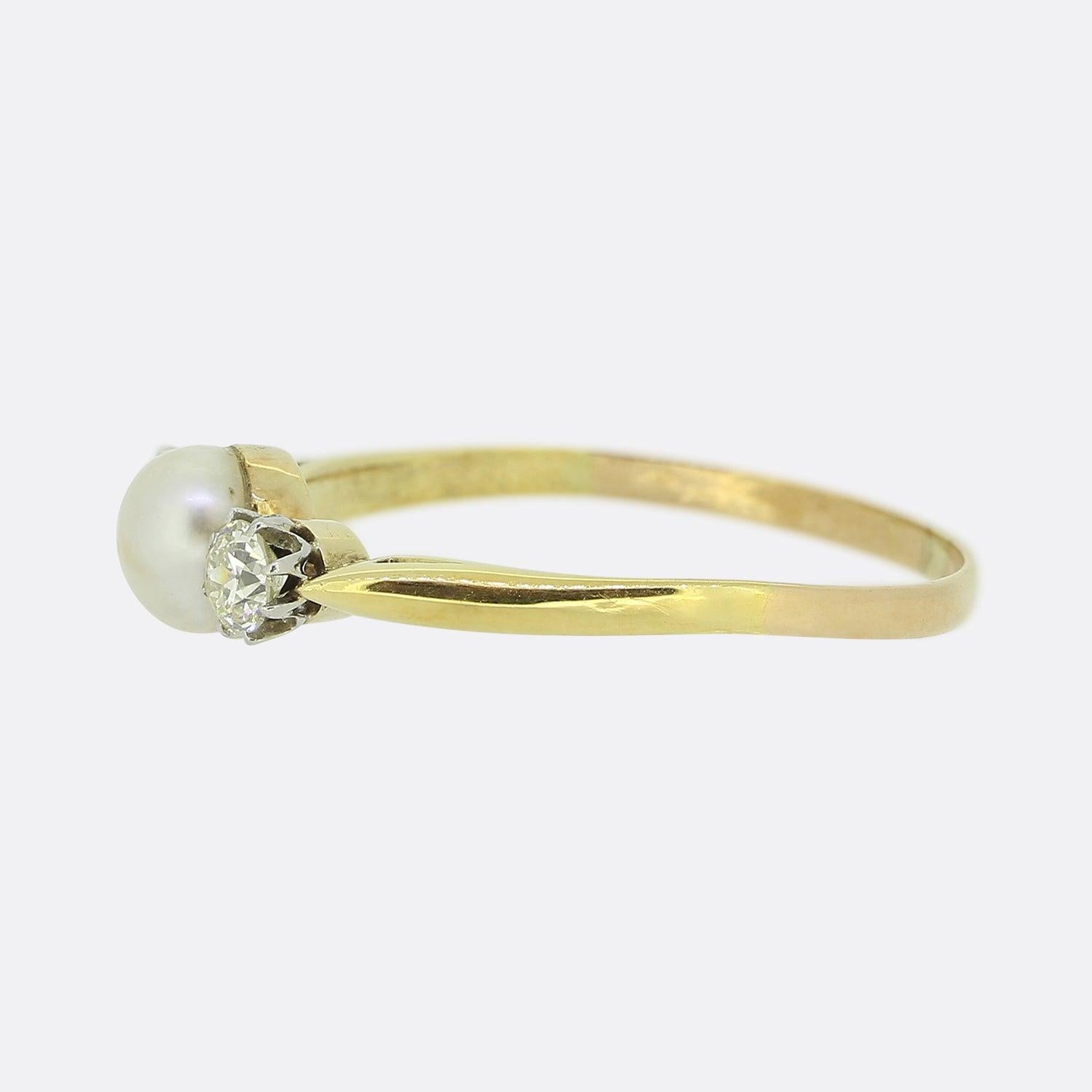 Here we have classic three-stone ring. A round natural pearl sits slightly risen at the centre of the face and is flanked on either side by a single round faceted old cut diamond in an 8 clawed platinum setting. This antique piece is finished with a