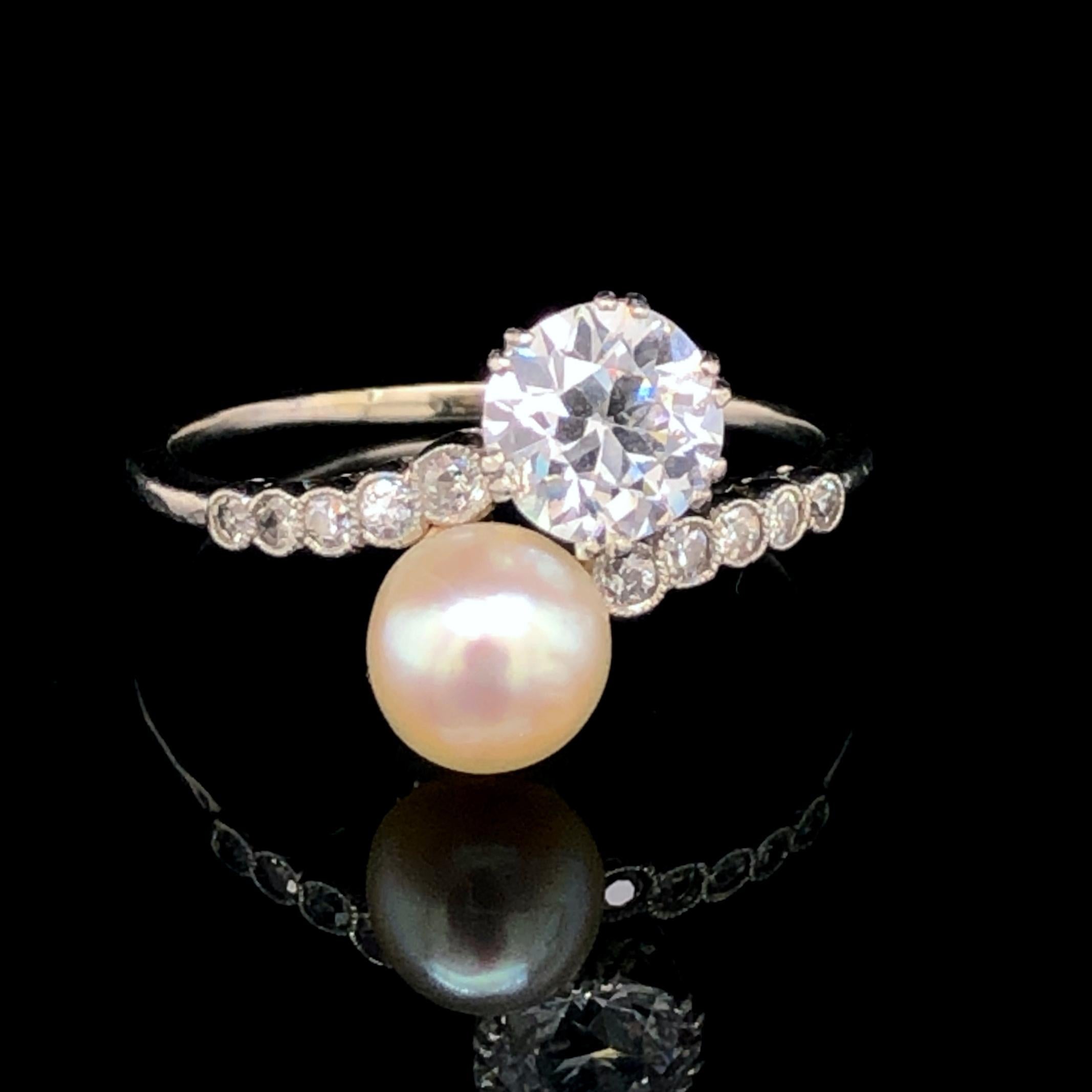 A lovely Edwardian natural pearl and diamond toi et moi crossover ring in platinum, ca. 1900s. 

The orient pearl button is a natural saltwater pearl with a beautiful lustre, measuring 7mm and accompanied by a gemological report from DSEF. It is set