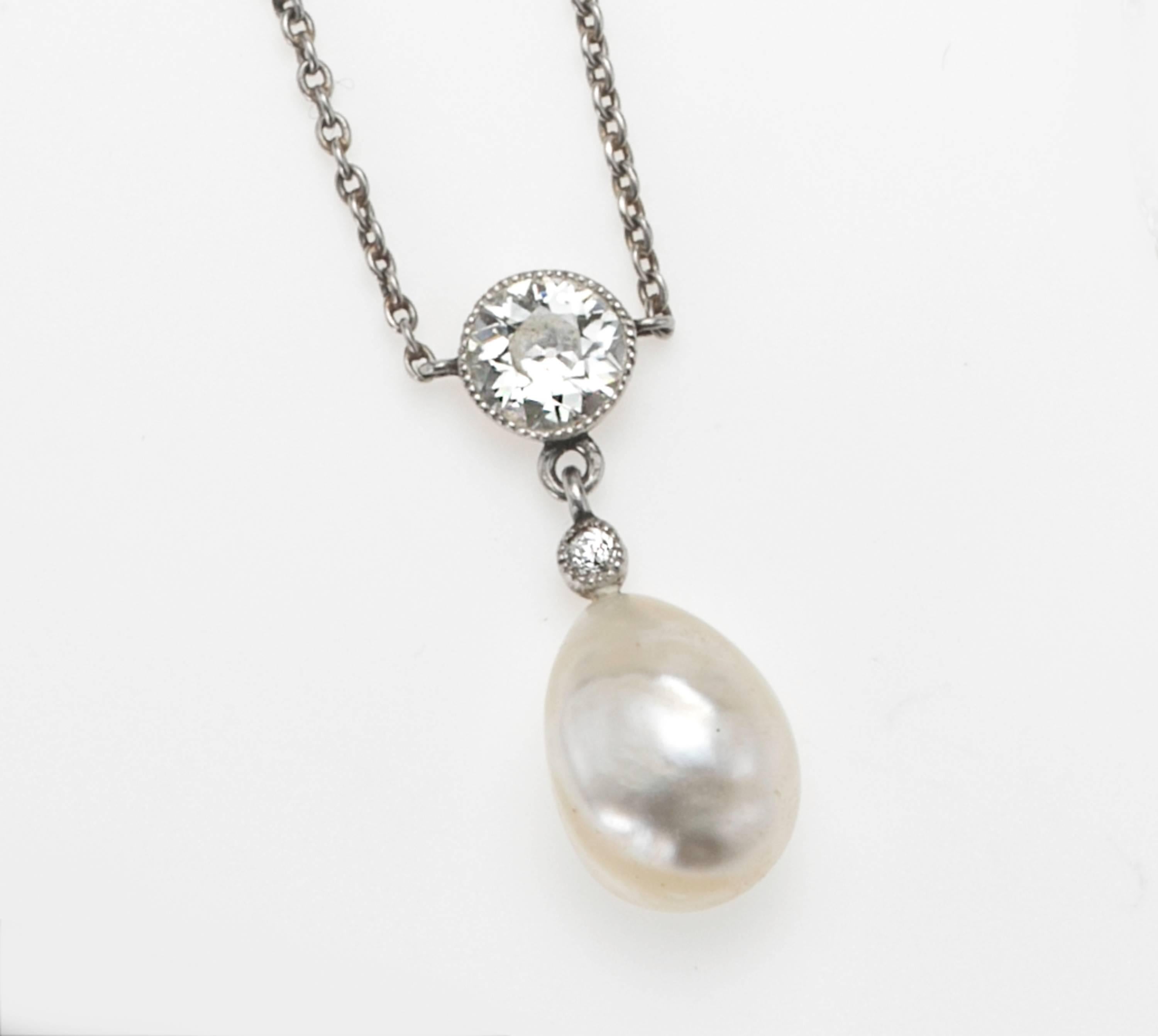 Platinum and gold Edwardian lavalier with Old Mine cut diamonds and a semi Baroque pearl.  No karat stamp is present and test indicates diamonds are set in both gold and platinum.  The pearl is set on a gold pin.  Chain is platinum 1.5 mm.cable link