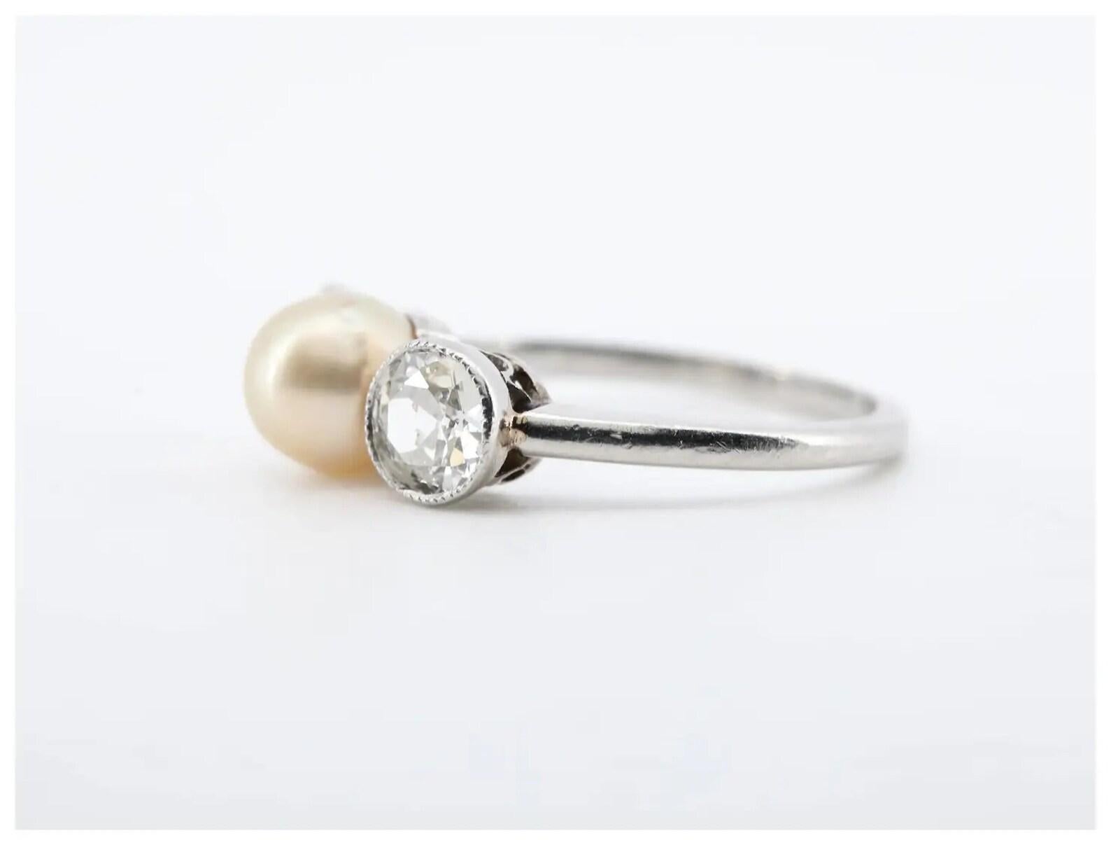 An Edwardian period natural pearl, and old European cut diamond ring crafted of platinum.

Centered by a 6mm diameter natural saltwater pearl of beautiful iridescent golden color.

Framed by twin bezel set old European cut diamonds of 0.80ctw with G