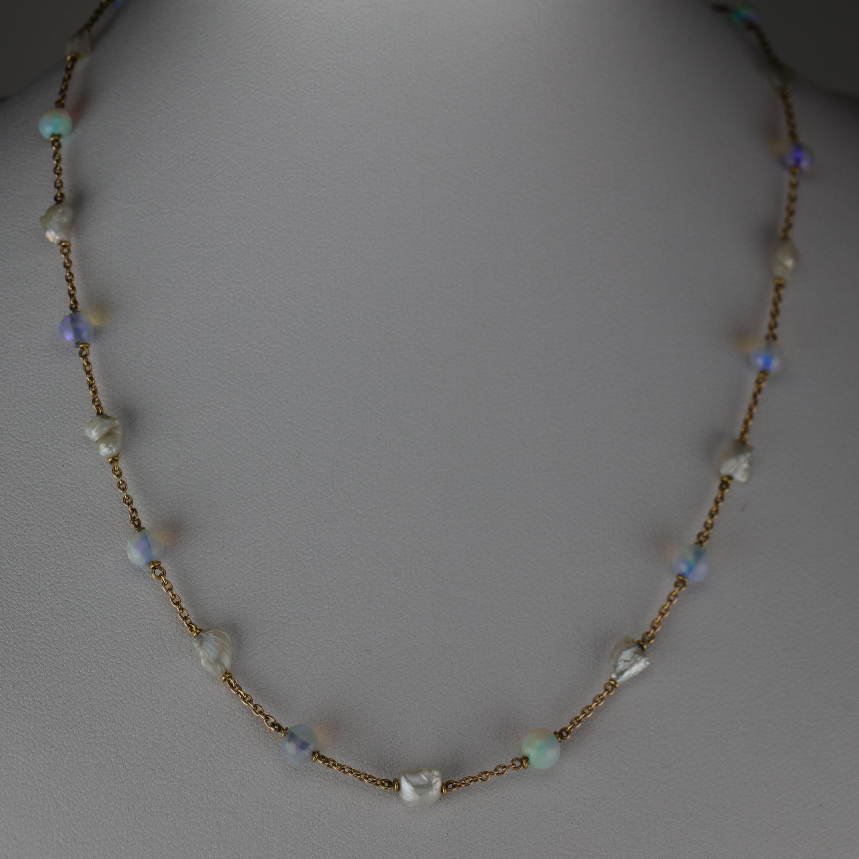 This Edwardian-era necklace of 18K yellow gold features alternating stations of opal beads and natural freshwater pearls. The natural pearls are freshwater river pearls and have retained their beautiful luster and colorful orient despite being over