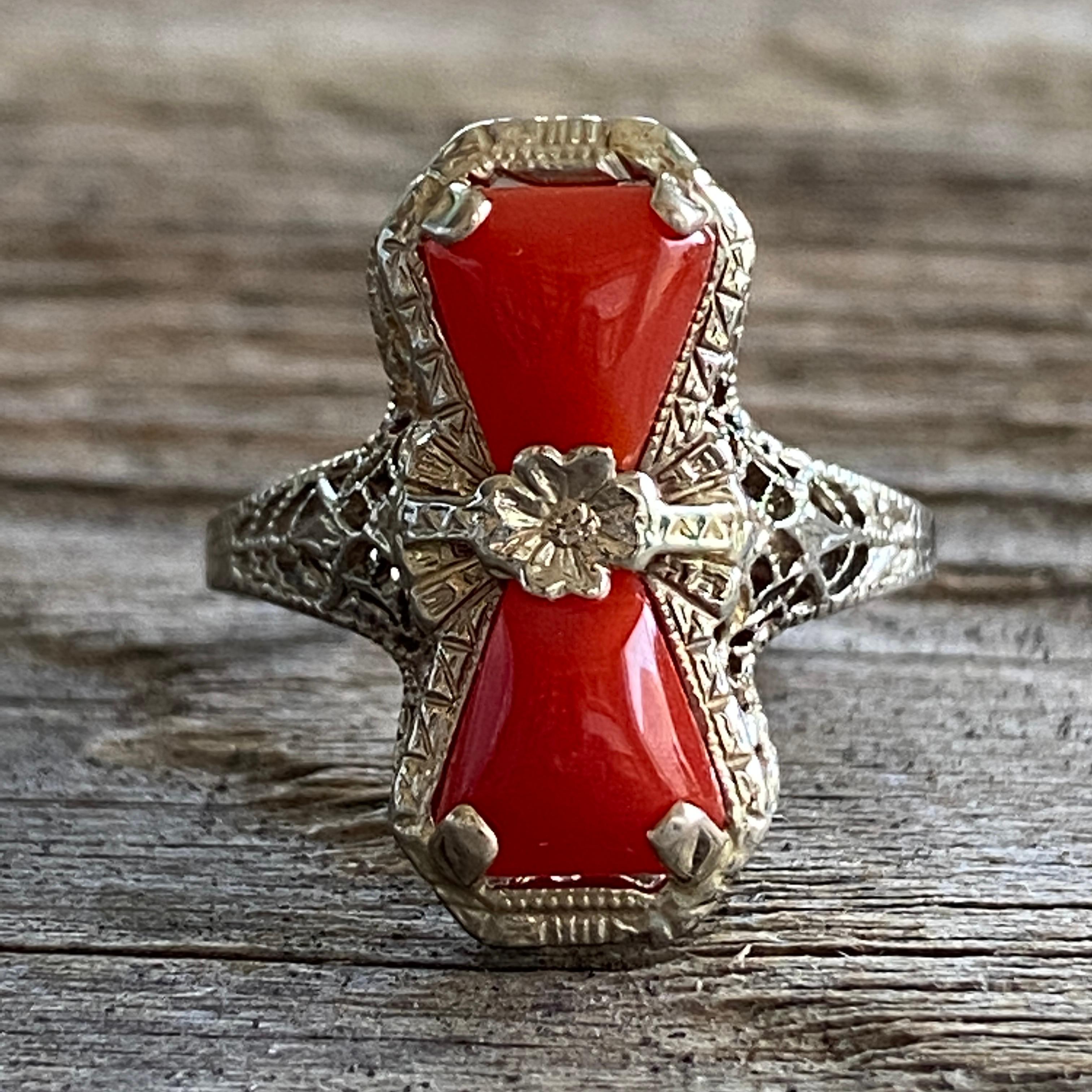 Details:
Lovely Edwardian 14K gold & natural red coral ring. The white gold filigree has lovely delicate details, a center pansy flower, with two beautiful bright red coral stones on either side. The ring is in excellent condition with no visible
