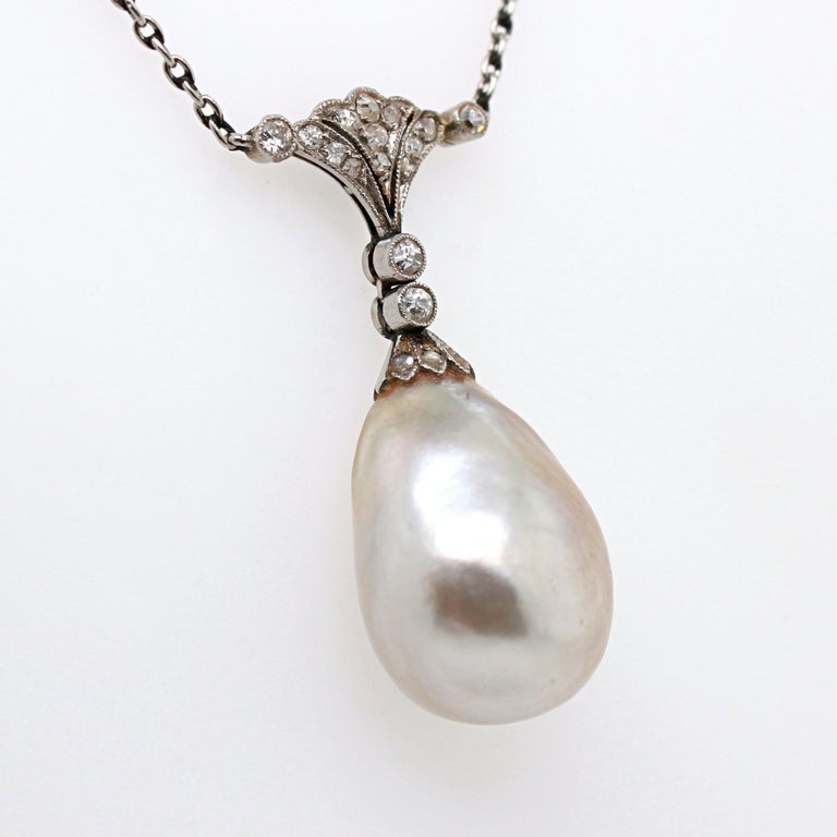 A natural pearl and diamond pendant from the Edwardian period, ca. 1910s. 
The pearl drop is a big natural saltwater basra pearl, weighing approximately 15 carats and measuring approximately 12.8 x 9.7 x 17mm. It has a beautiful orient colour and