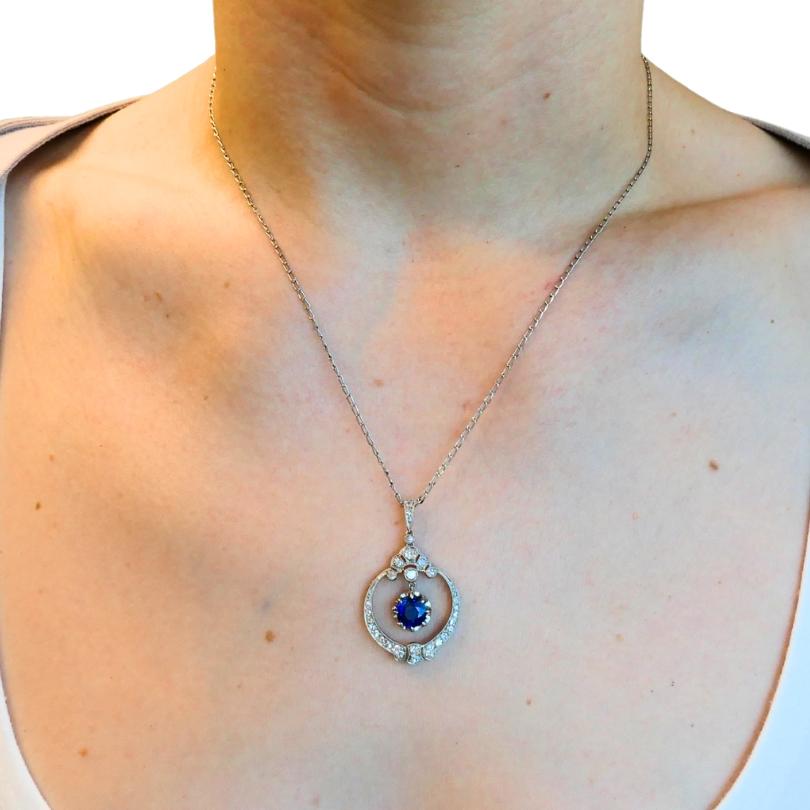 Eine wunderschöne edwardianische Halskette aus Platin mit einem Anhänger aus Saphiren und Diamanten. 
In der Mitte hängt ein tiefblauer Saphir, der in einem kreisförmigen durchbrochenen Rahmen schwebt und von Diamanten umgeben ist, die entlang des