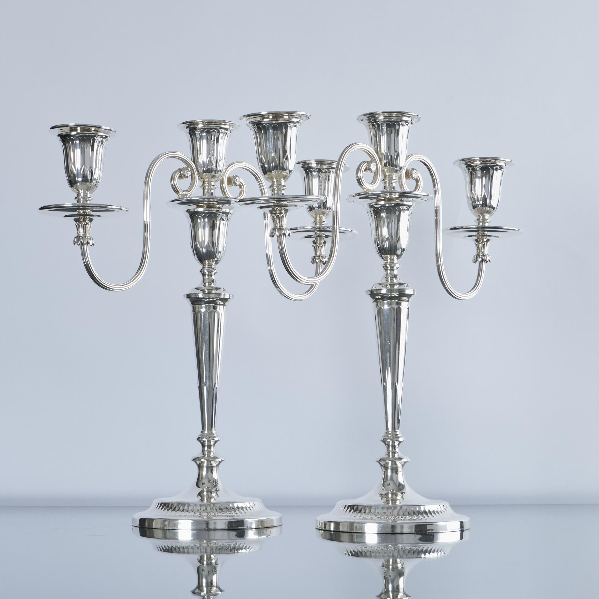 Very good pair of elegant two-branch, three-light, neoclassical silver candelabra in the Adam style. The branches are detachable, allowing the candlesticks to be used separately and the the wax drips or nozzles are also detachable, making them