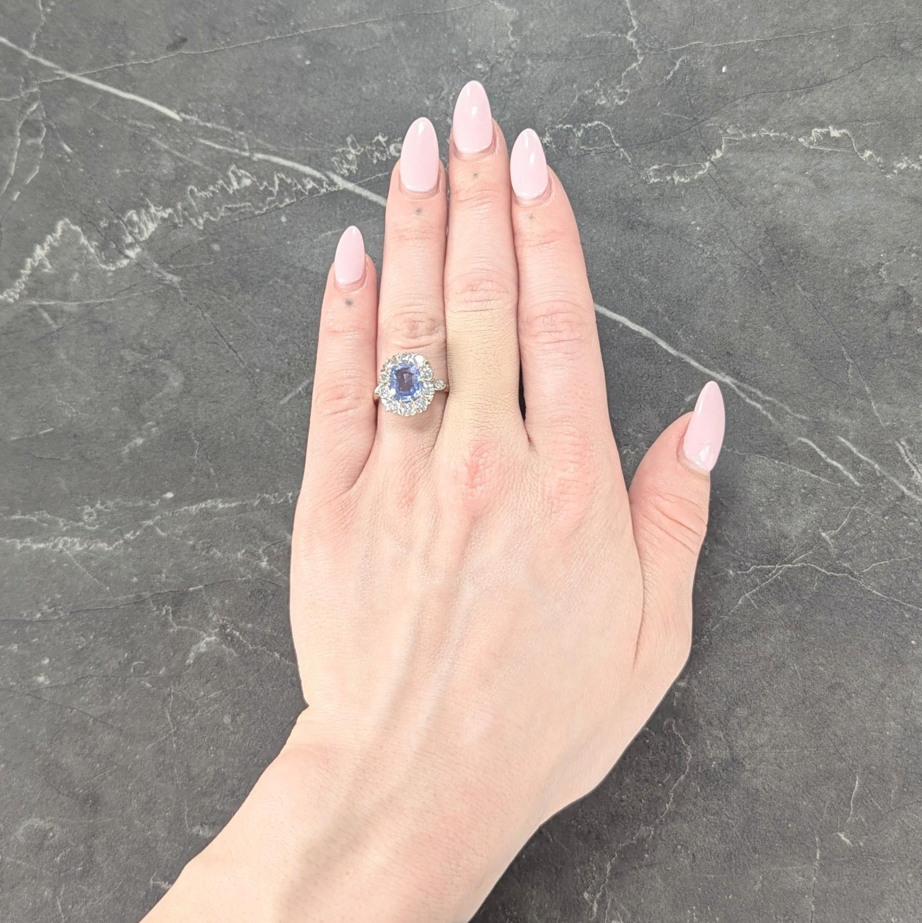 Centering a mixed cushion cut sapphire weighing approximately 2.25 carats total - transparent light blue
Natural Ceylon (Sri Lankan) in origin and displaying no indications of heat treatment
Set with yellow gold a talon prongs with a halo surround