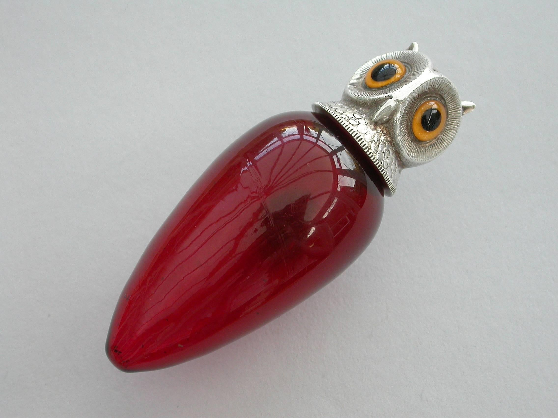 A rare Edwardian novelty silver mounted ovoid red glass scent bottle, the screw-off cover formed as an owl's head set with yellow glass eyes.

By Sampson Mordan & Co, Chester, 1904.