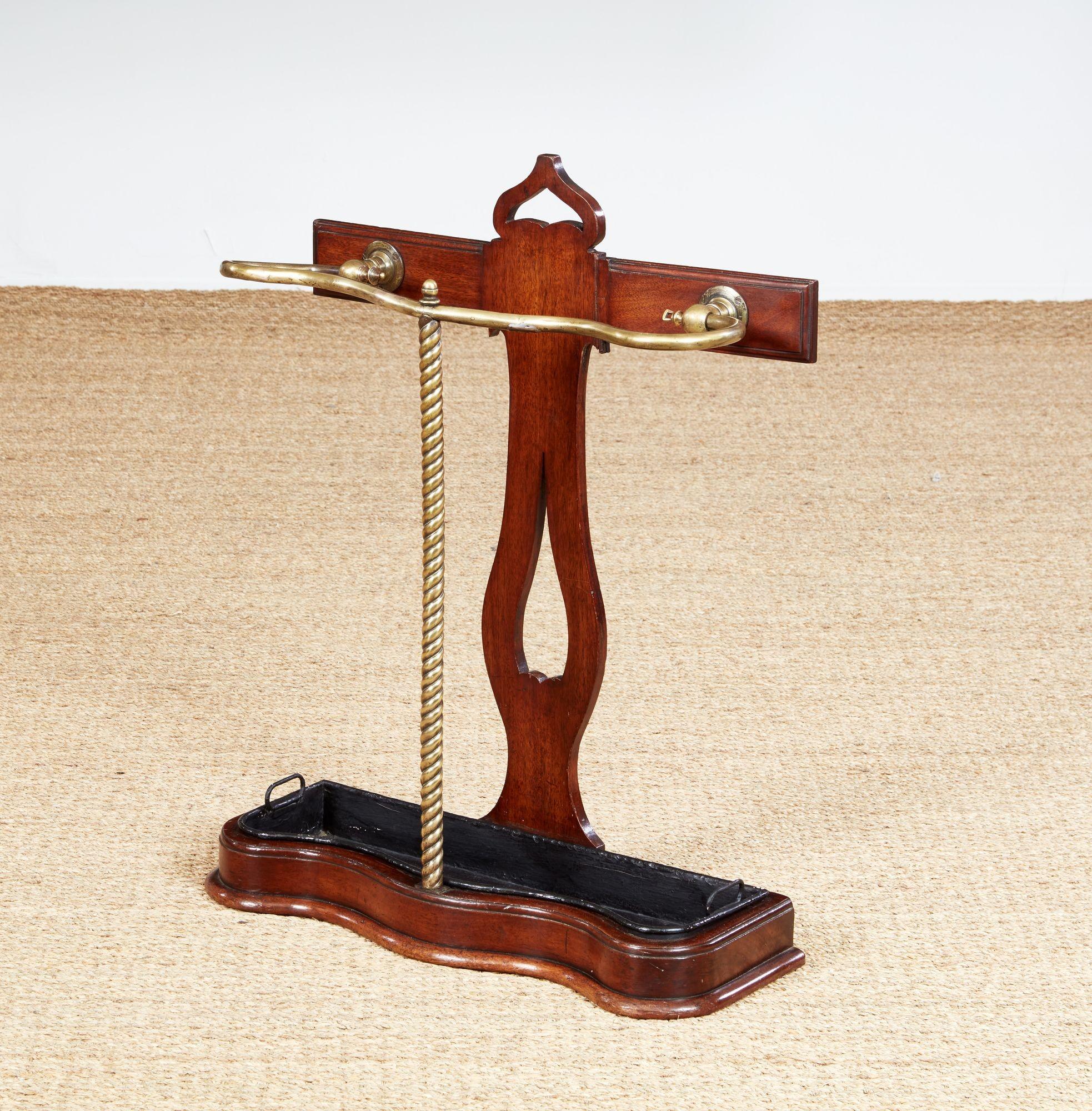Buon portaombrelli inglese della fine del XIX secolo, in Oak e ottone, con binario in ottone a serpentina su supporto in corda d'ottone e base sagomata, che conserva il parapioggia originale, la parte posteriore con decorazioni traforate e maniglia