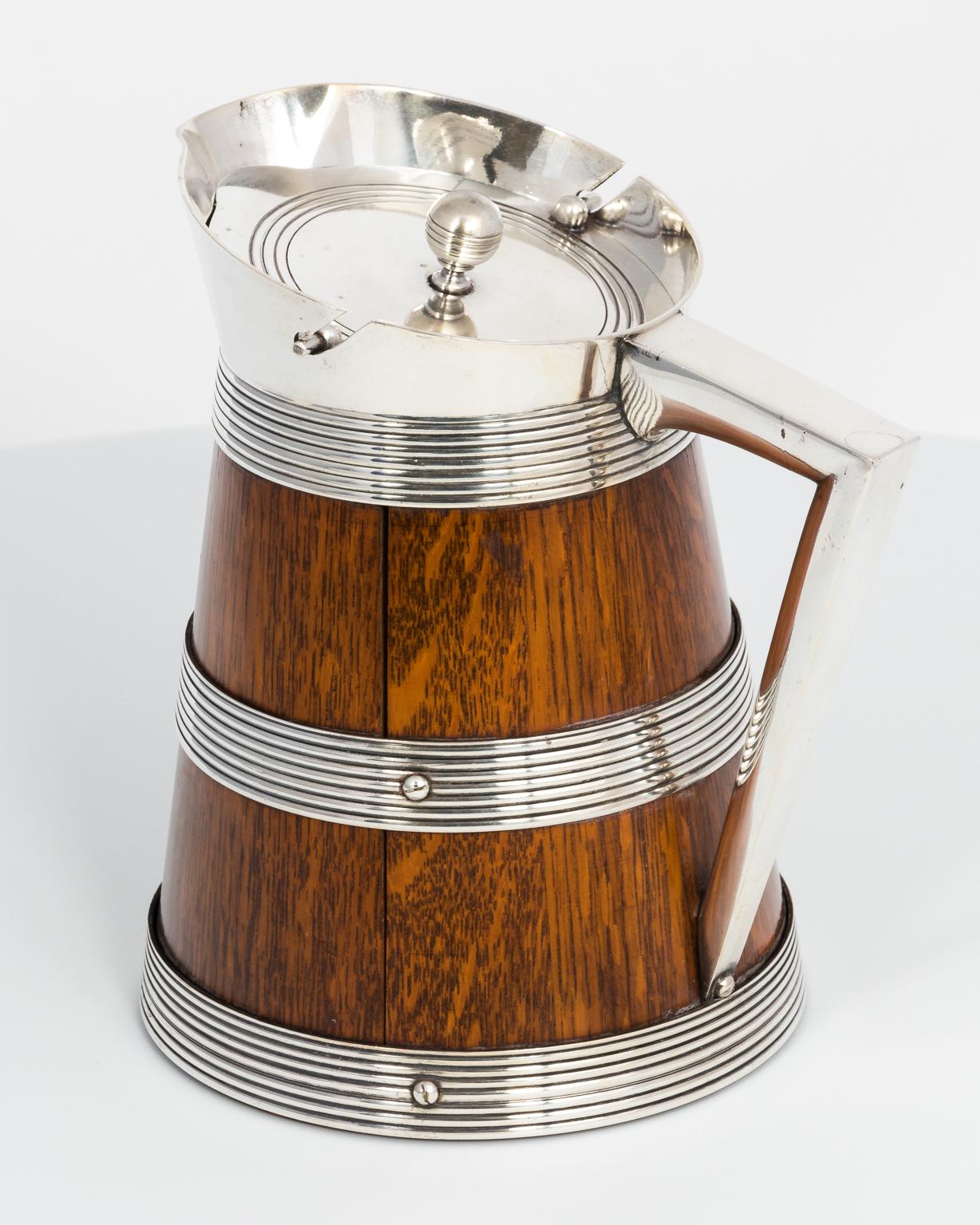 Edwardian oak and silver plated covered jug, circa 1890s.