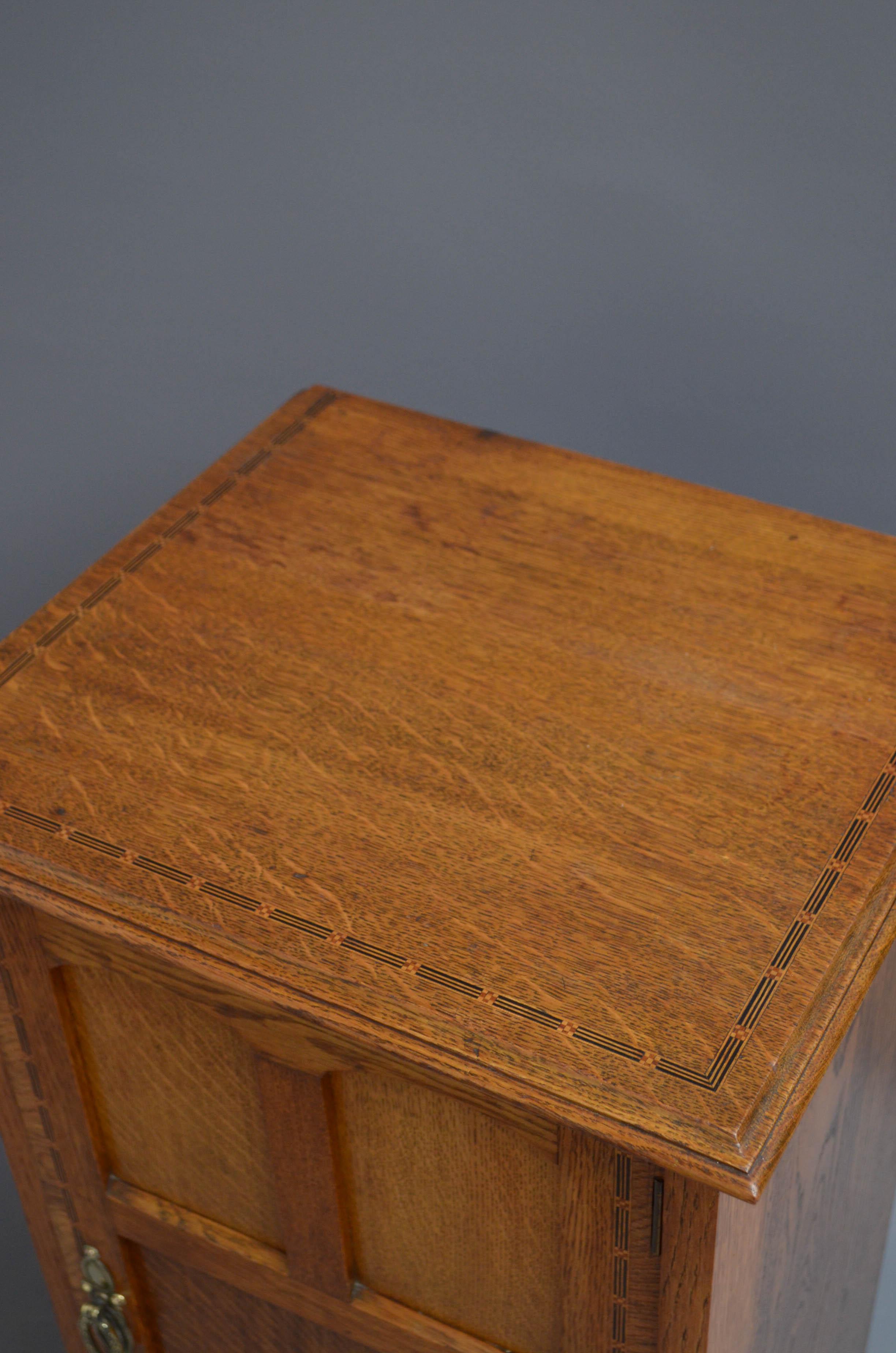 Sn5152 Edwardian bedside cabinet in oak, having inlaid and moulded top above panelled doors fitted with original brass handle, all standing on plinth base. This antique cabinet retains its original finish which has been cleaned and waxed, all in