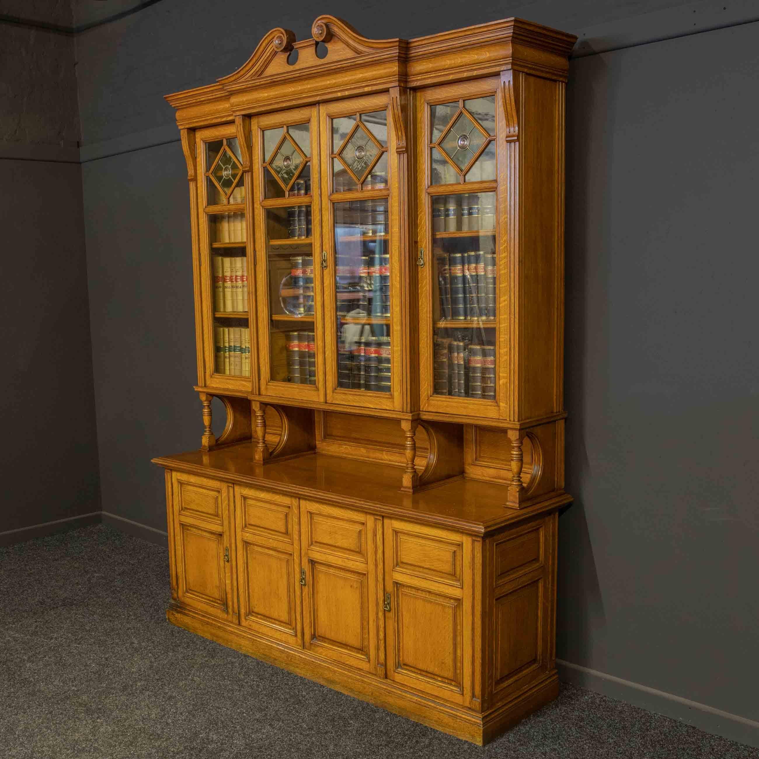 The upper structure of this bookcase is of breakfront design with a superb swan neck pediment to it's ogee shaped cornice. The astragal glazed doors have a diamond shaped leaded window to the upper most section complete with a central 'bullseye'.
