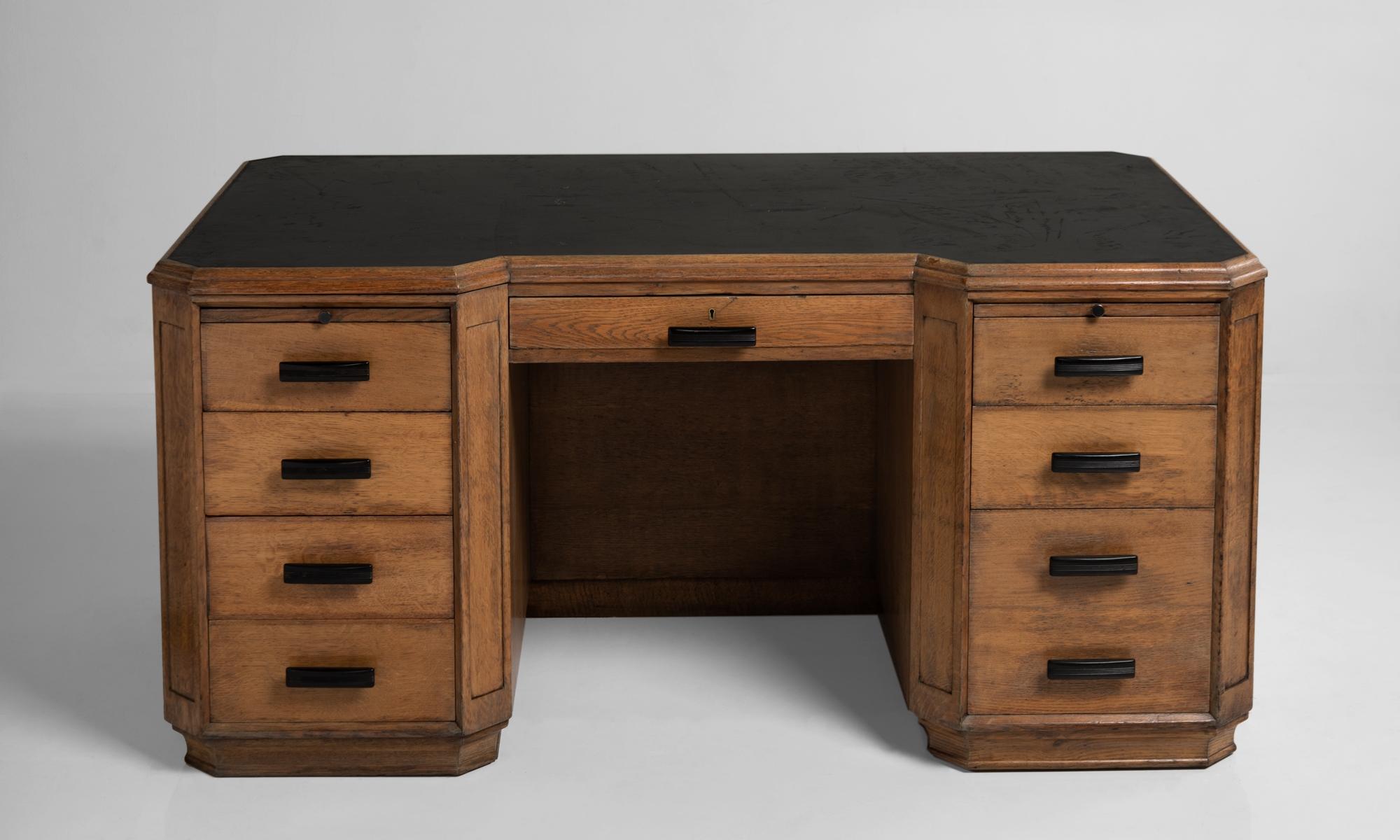Edwardian oak desk, England, circa 1910.

With black leather surface, ebonized pulls, drawers and cabinets for storage.